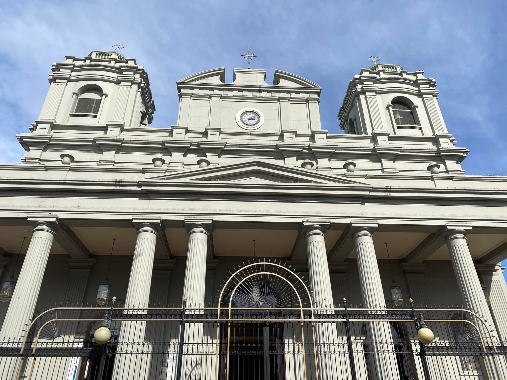 Columned exterior and twin bell towers of the Metropolitan Cathedral of San José beneath a blue sky.