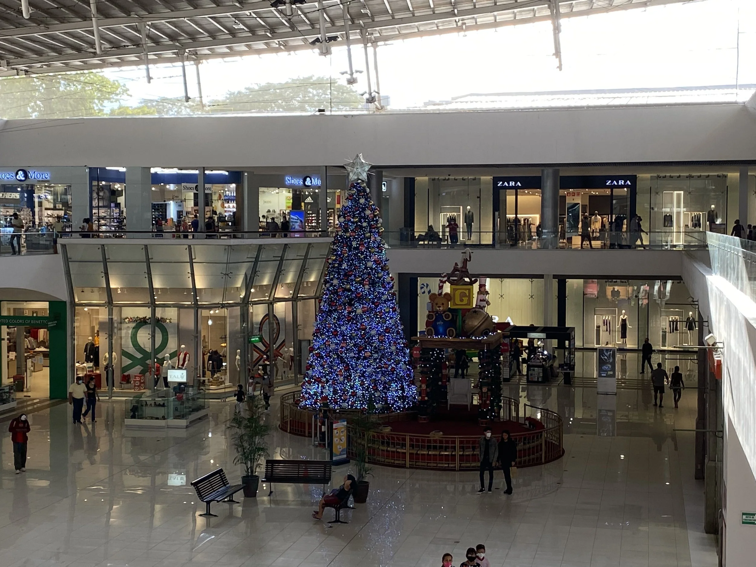 Modern shopping mall in Managua, Nicaragua decorated with a large Christmas tree and retail stores