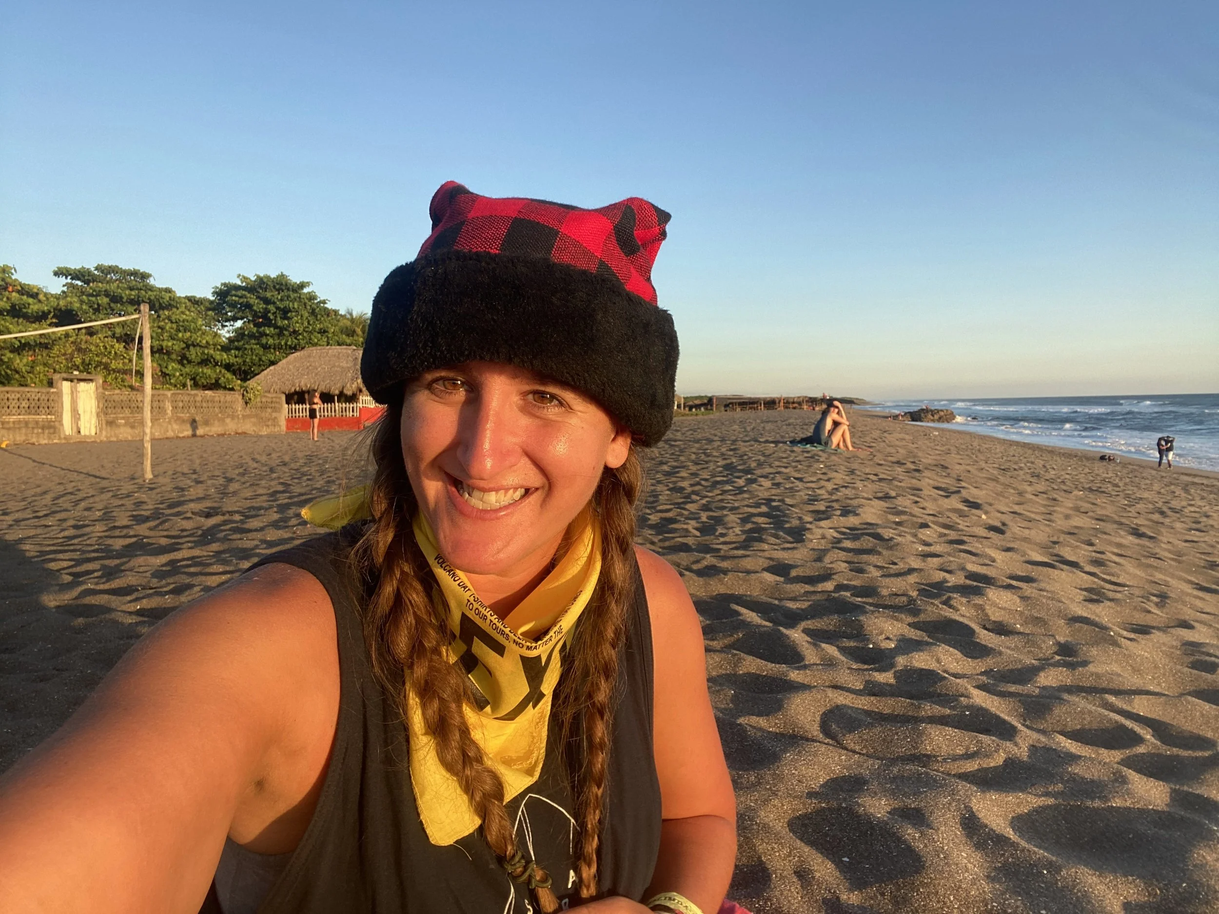 Solo female traveler smiling on a wide sandy beach in Las Peñitas, Nicaragua during sunset on her first day