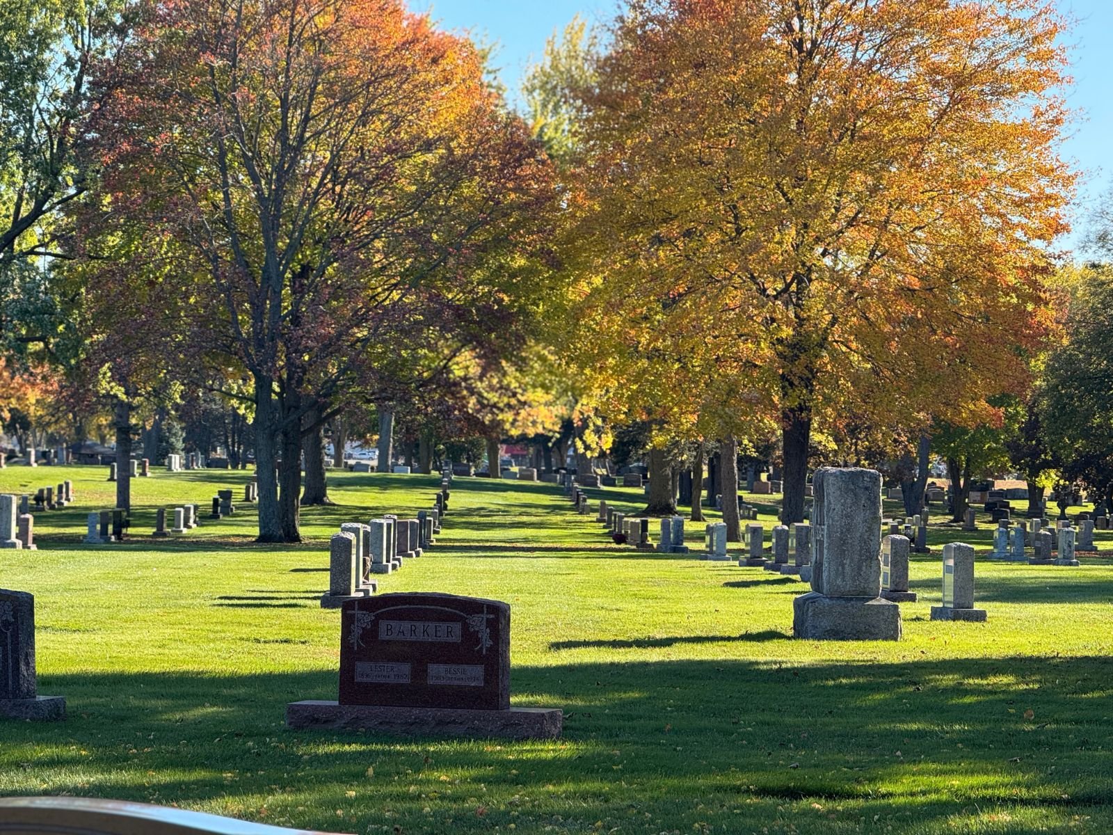 Well-maintained cemetery lawn with headstones and trees