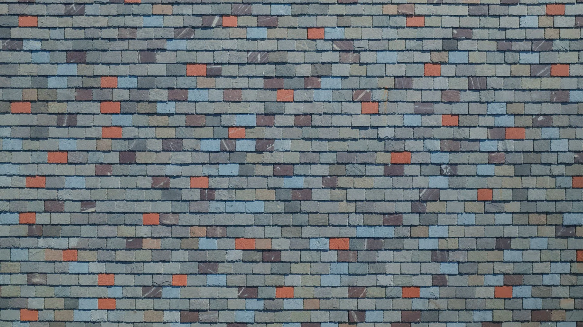 A wall covered with multicolored small rectangular tiles, predominantly in shades of blue, gray, brown, and red.