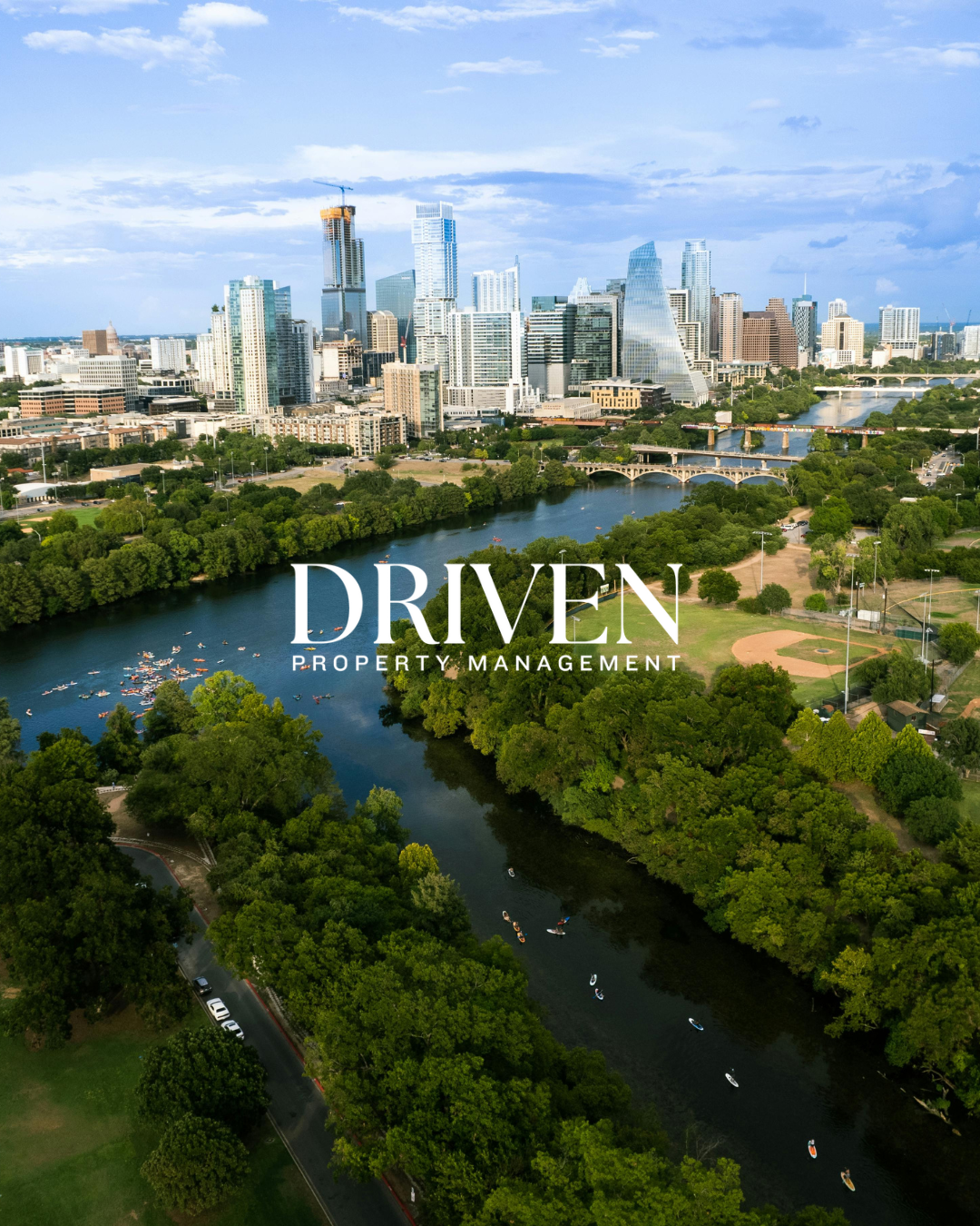 Aerial view of a city skyline with tall skyscrapers, a river with paddle boats, and green park areas in the foreground, with the text 'DRIVEN PROPERTY MANAGEMENT' overlaid.