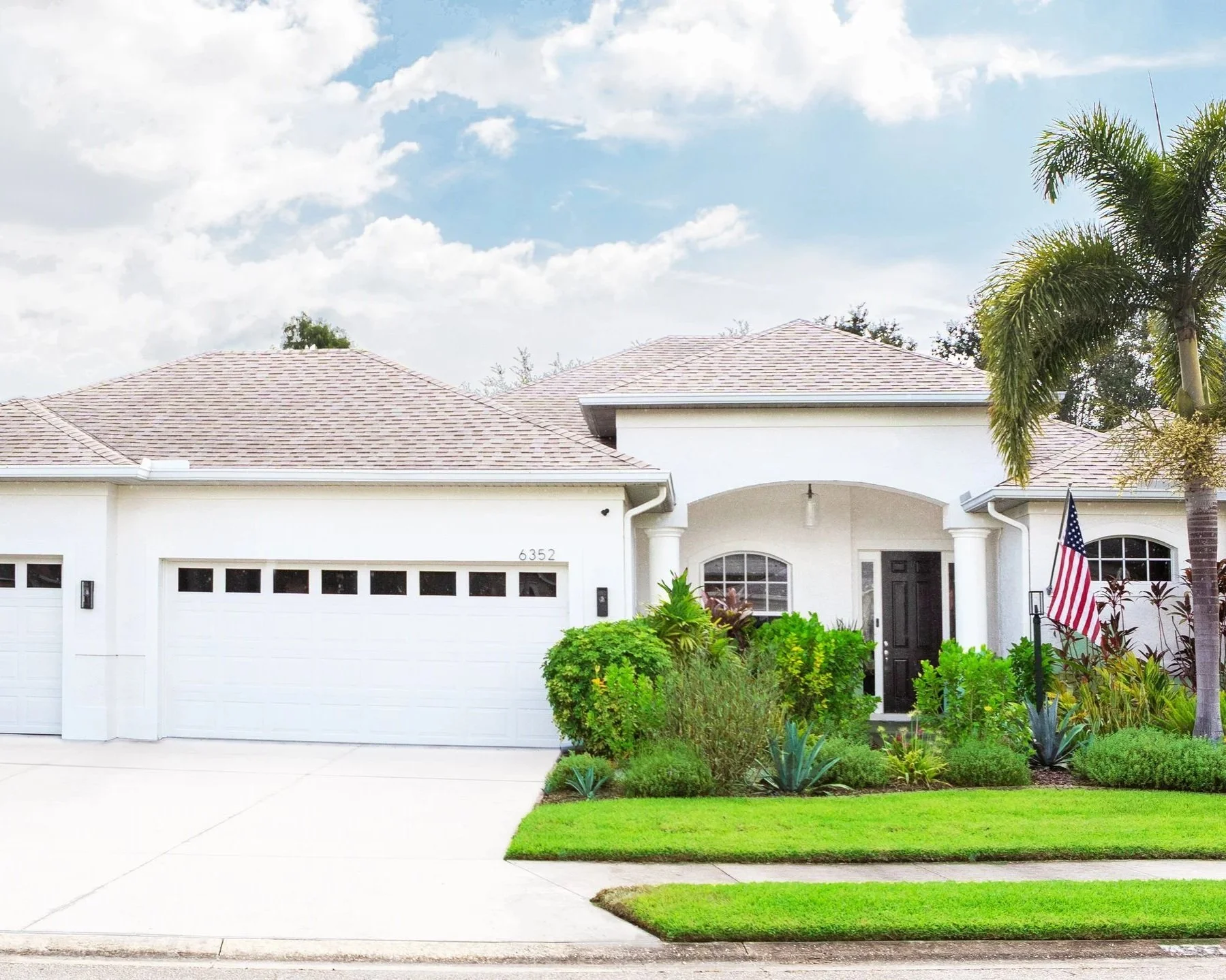 After photo of home exterior repainted white  with updated landscaping in Lakewood Ranch  Florida by Kitt and Kaboodle