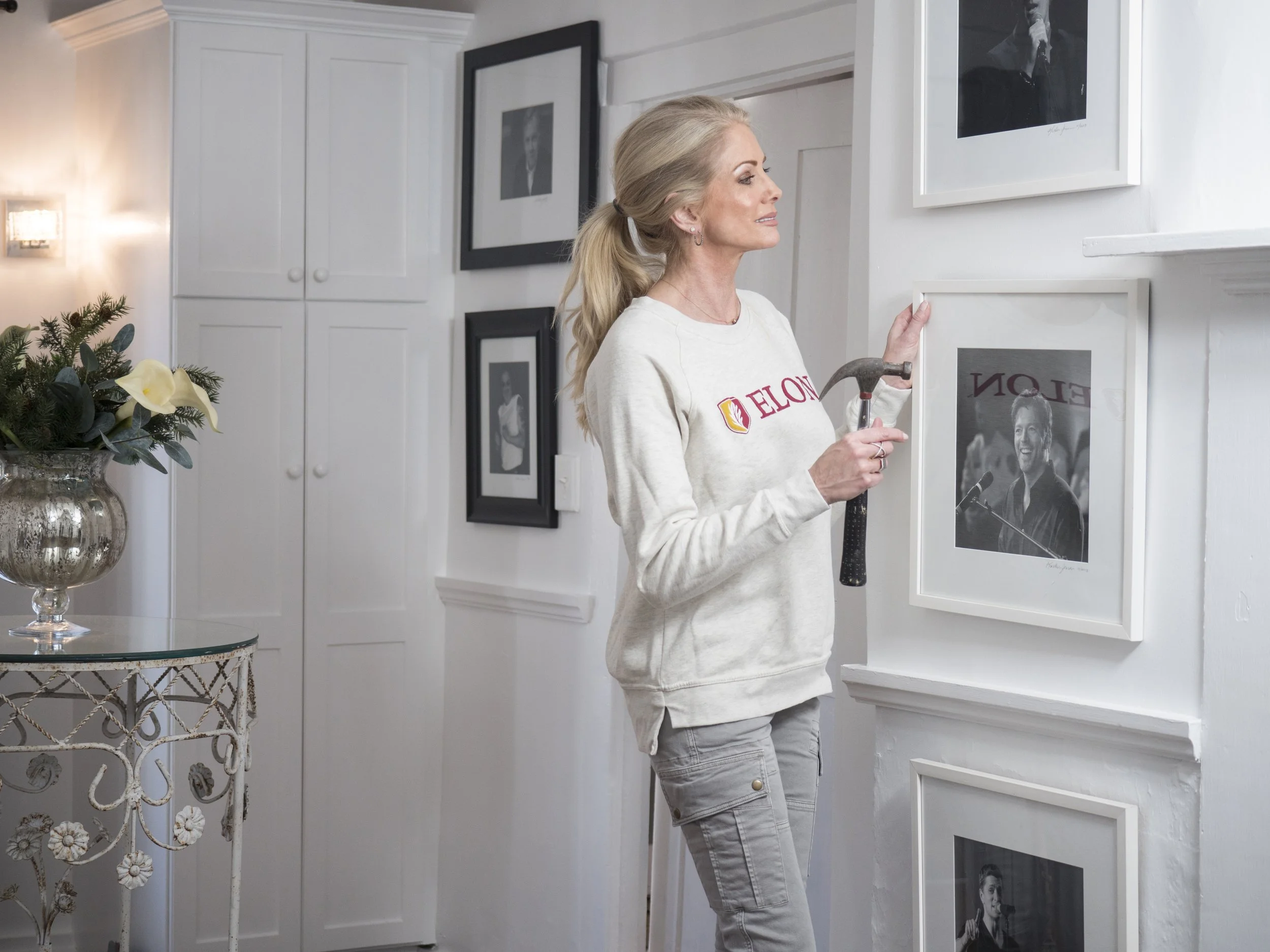 Kristen Jensen interior stylist and home stager  hanging artwork in Lakewood Ranch Florida home