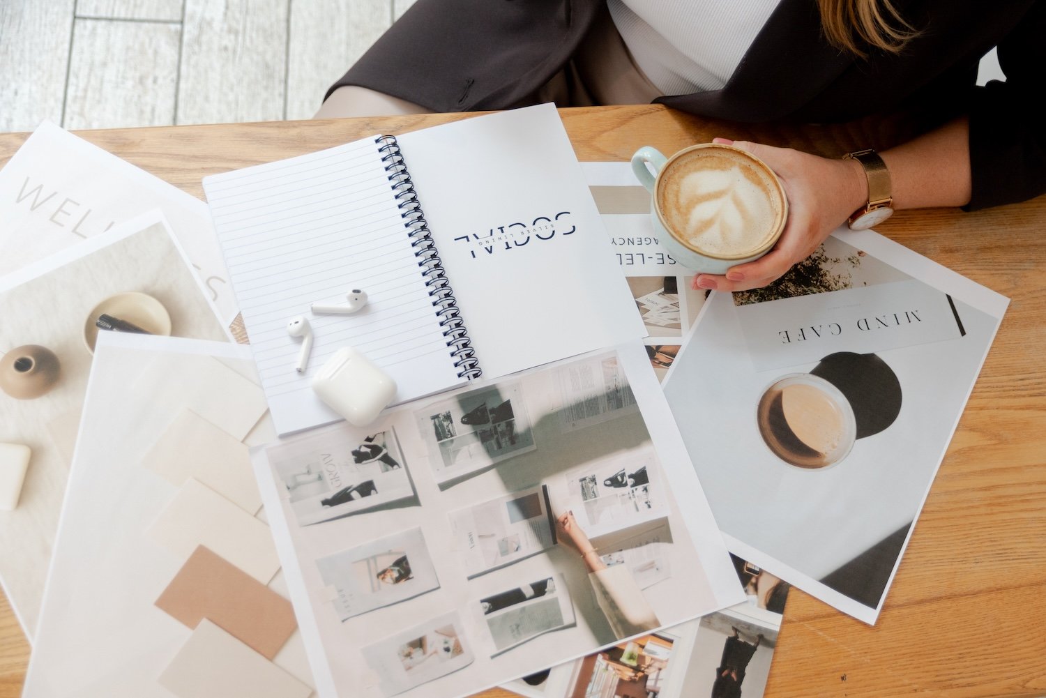 Grace from Silver Lining Social planning content strategy at a desk with magazines, printouts and a coffee.