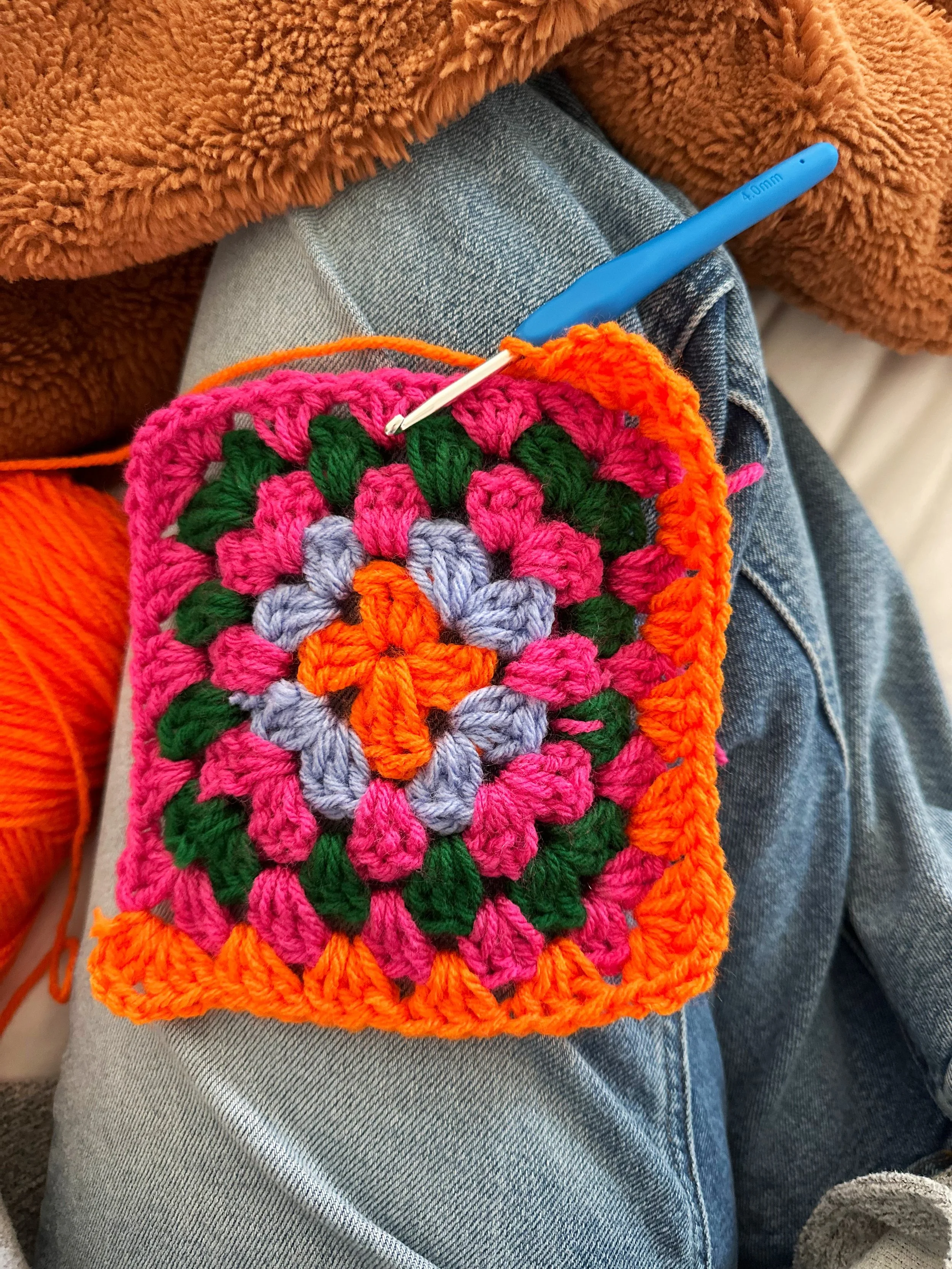 Colourful crochet project being made by hand with yarn and a crochet hook