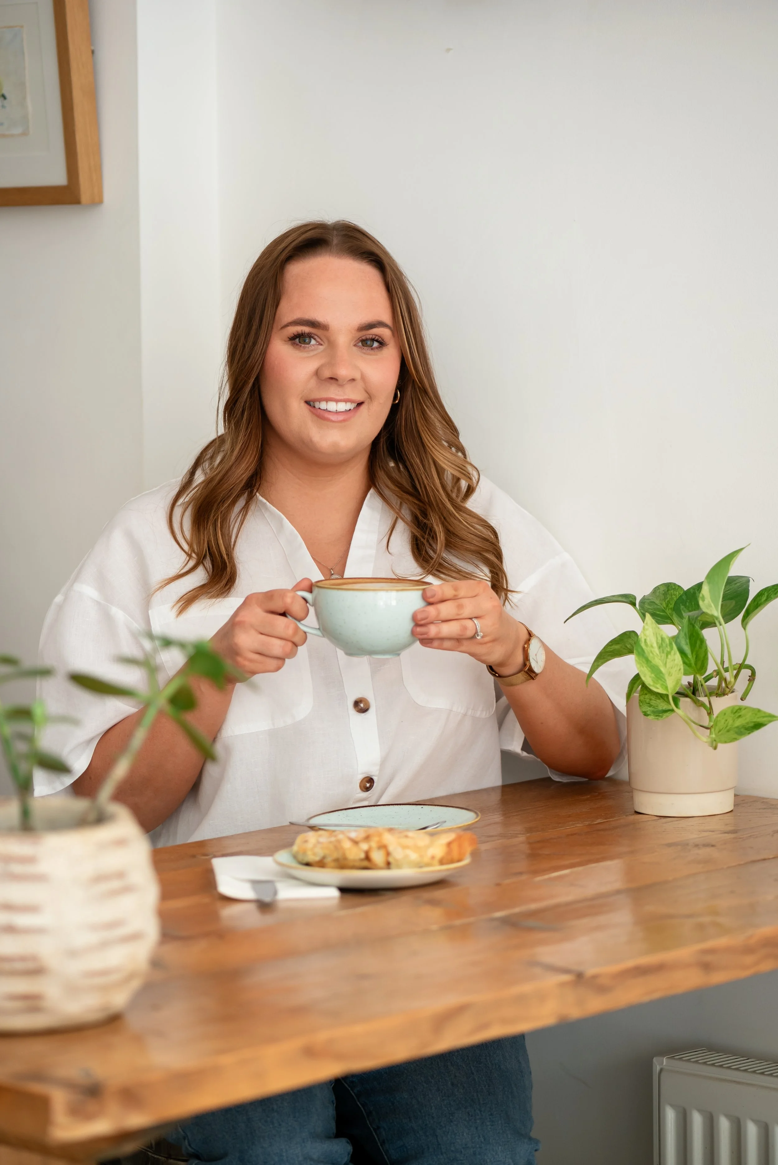 Grace from Silver Lining Social smiling with a coffee in a bright café setting