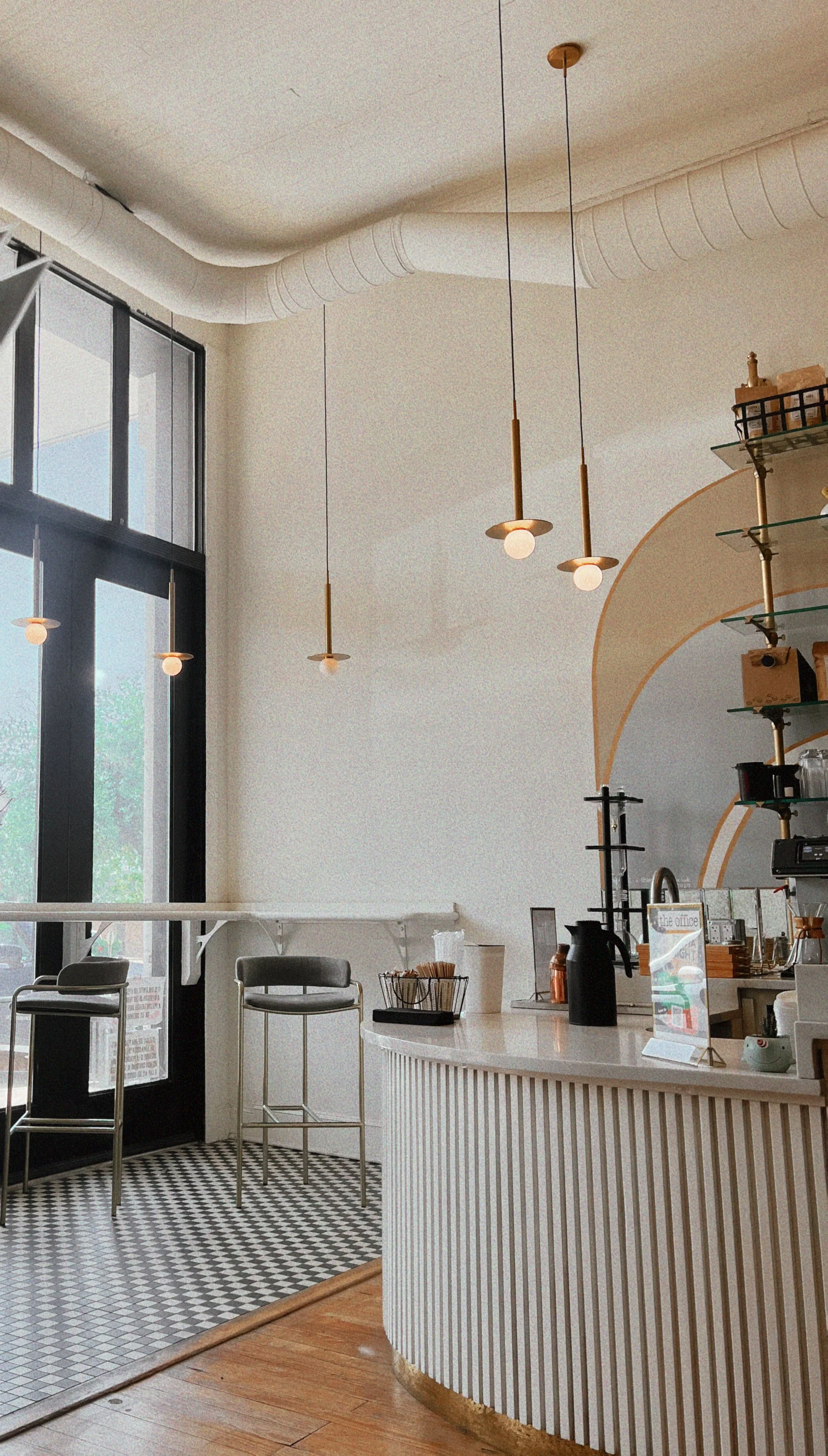 Modern café interior with pendant lighting, coffee equipment and large windows
