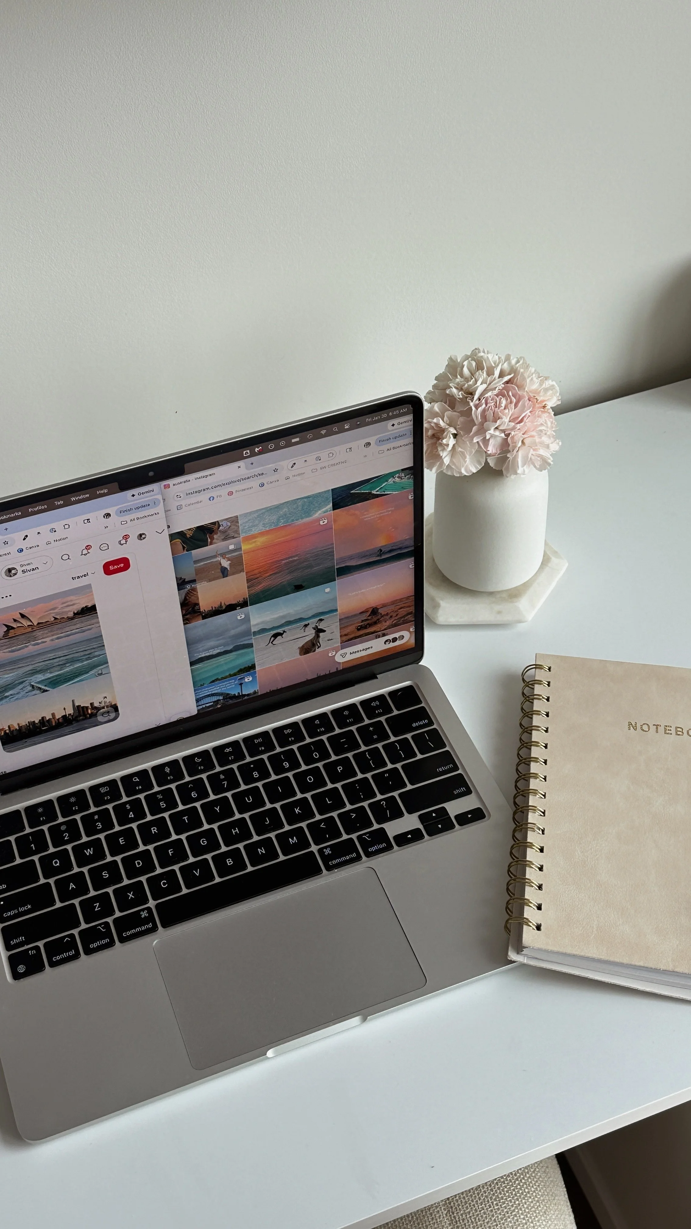 Laptop displaying social media content alongside a notebook during a content planning session