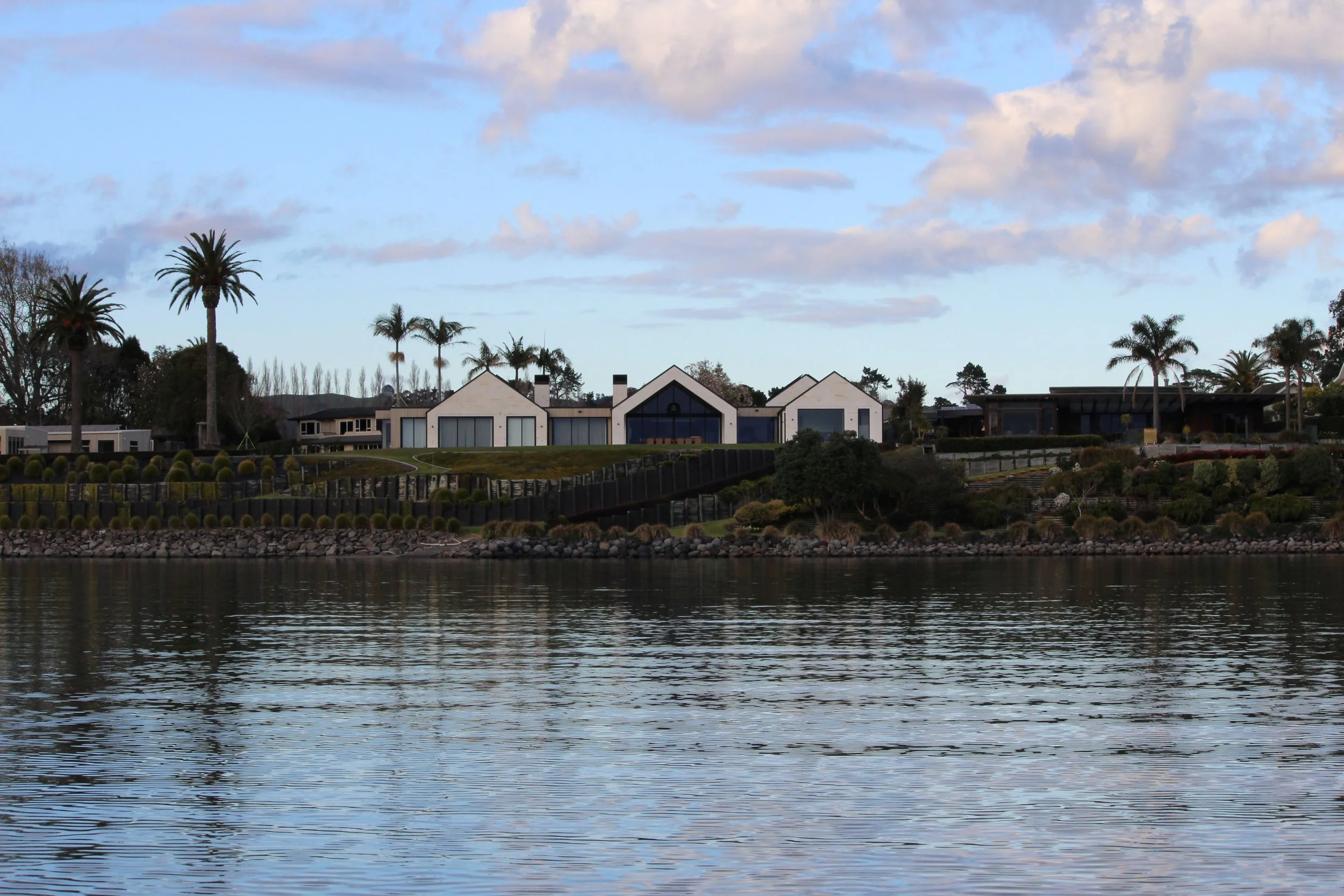 Water view of Harbour View home in Tauranga with natural stone and timber cladding