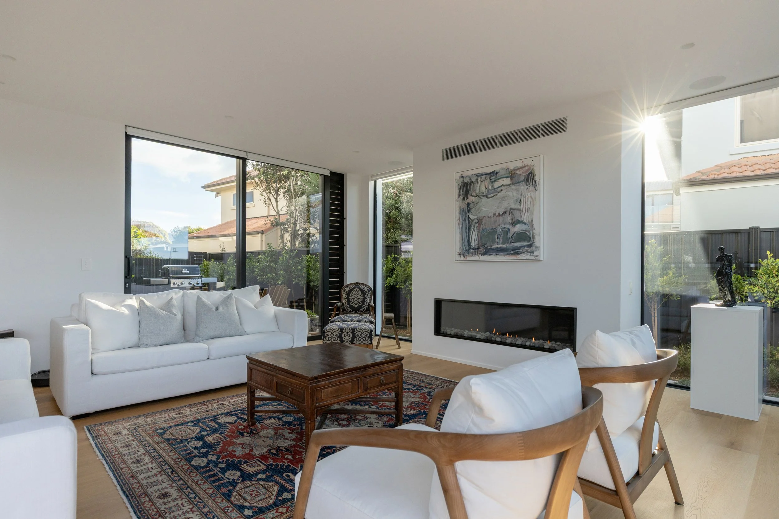 Open-plan living area in Beachside Minimalism Tauranga home with panoramic glazing
