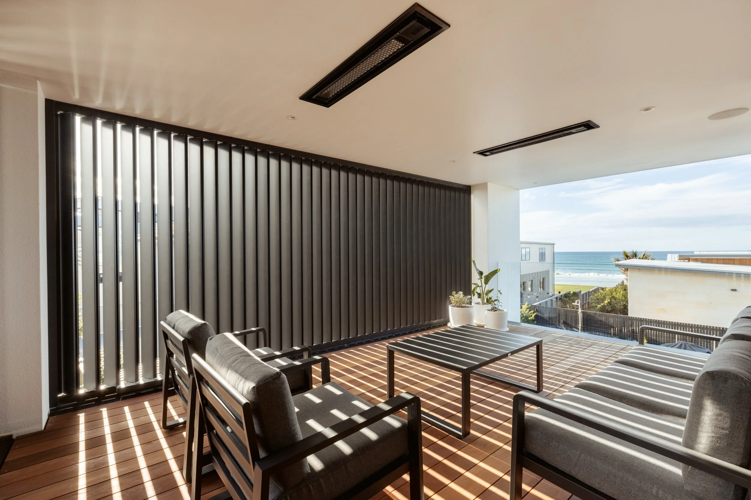 Outdoor living area of Beachside Minimalism Tauranga home with beach views and architectural louvres
