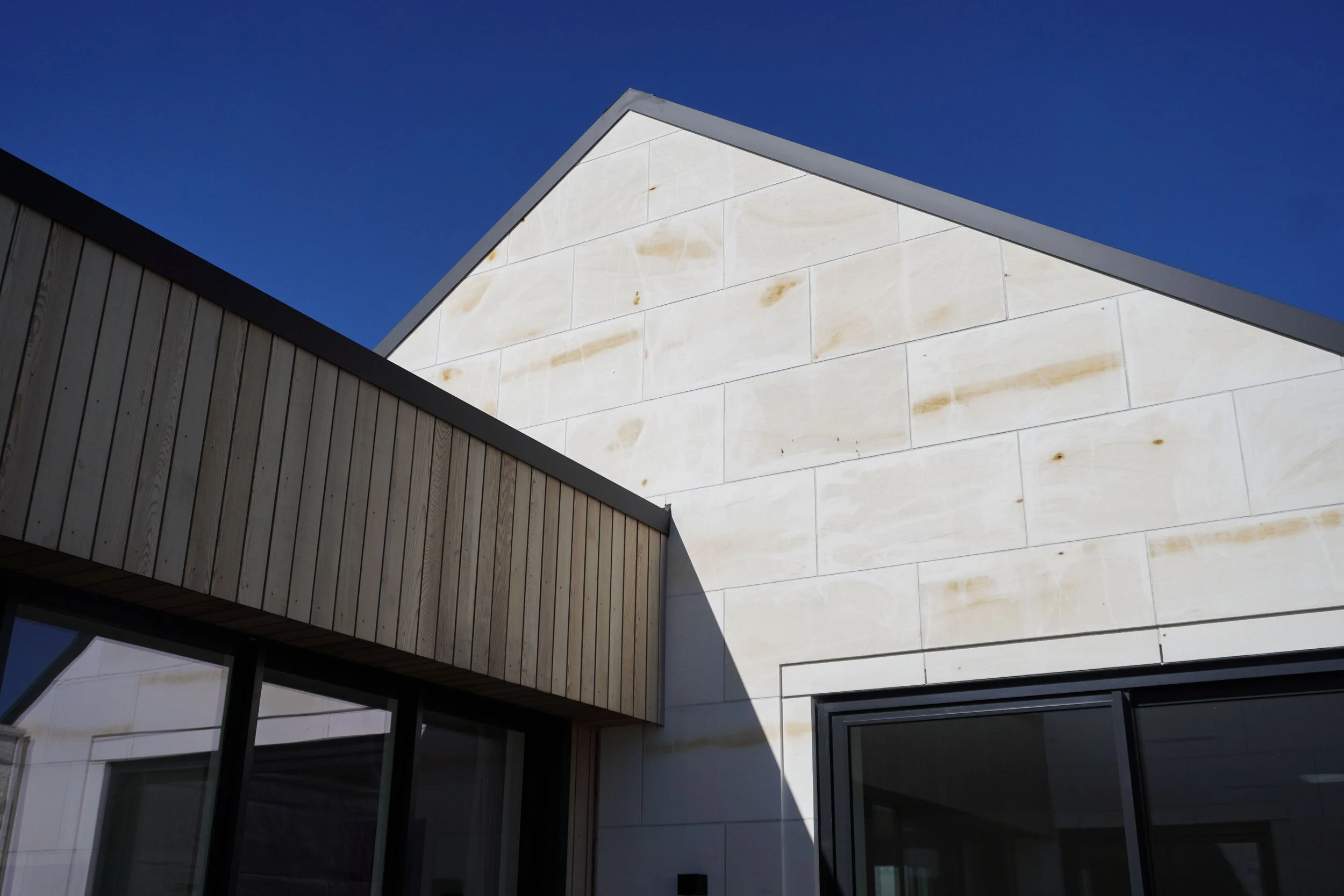 Exterior of Harbour View home in Tauranga with natural stone and timber cladding
