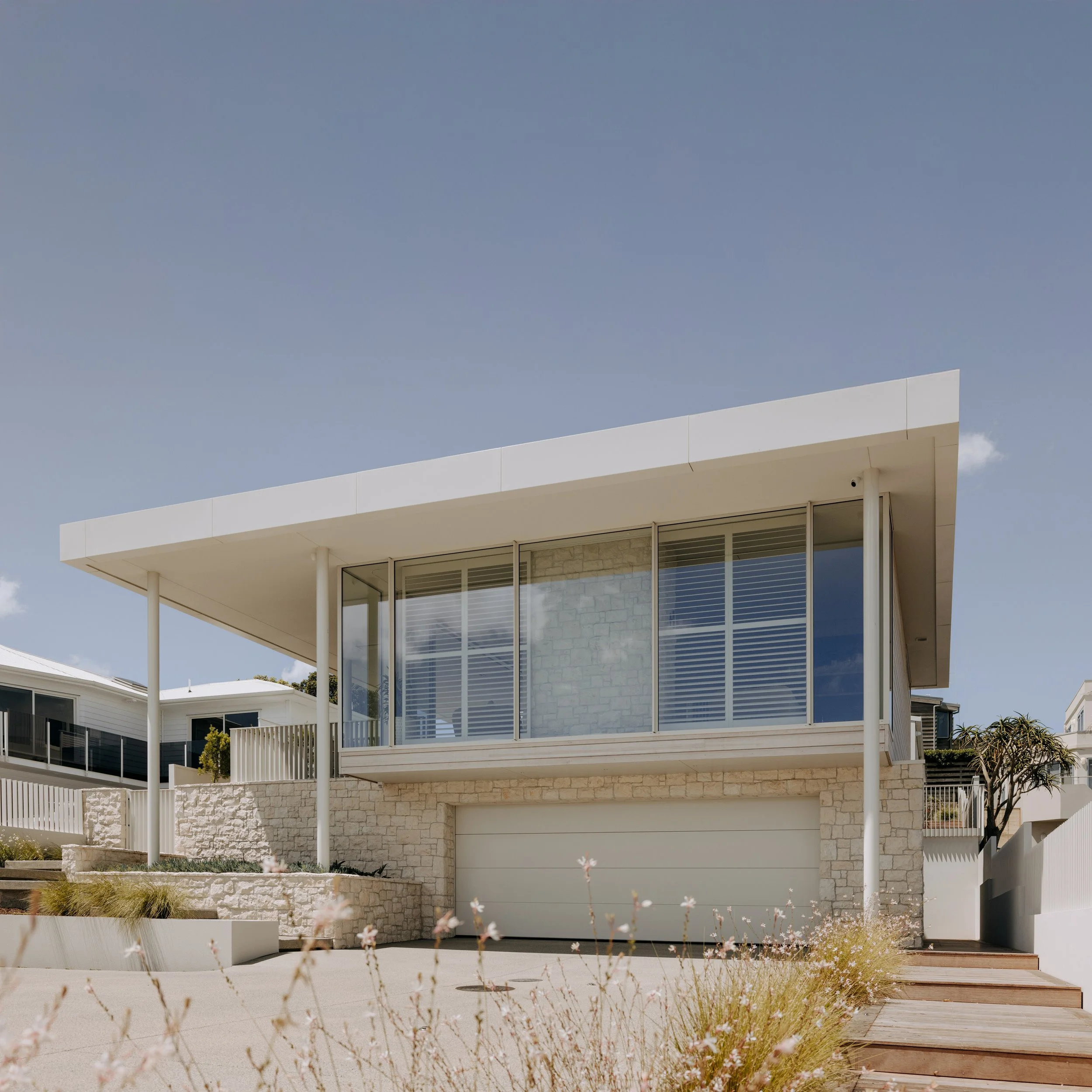 Roadside facade of Palm Springs Mount Maunganui home renovation with natural stone.