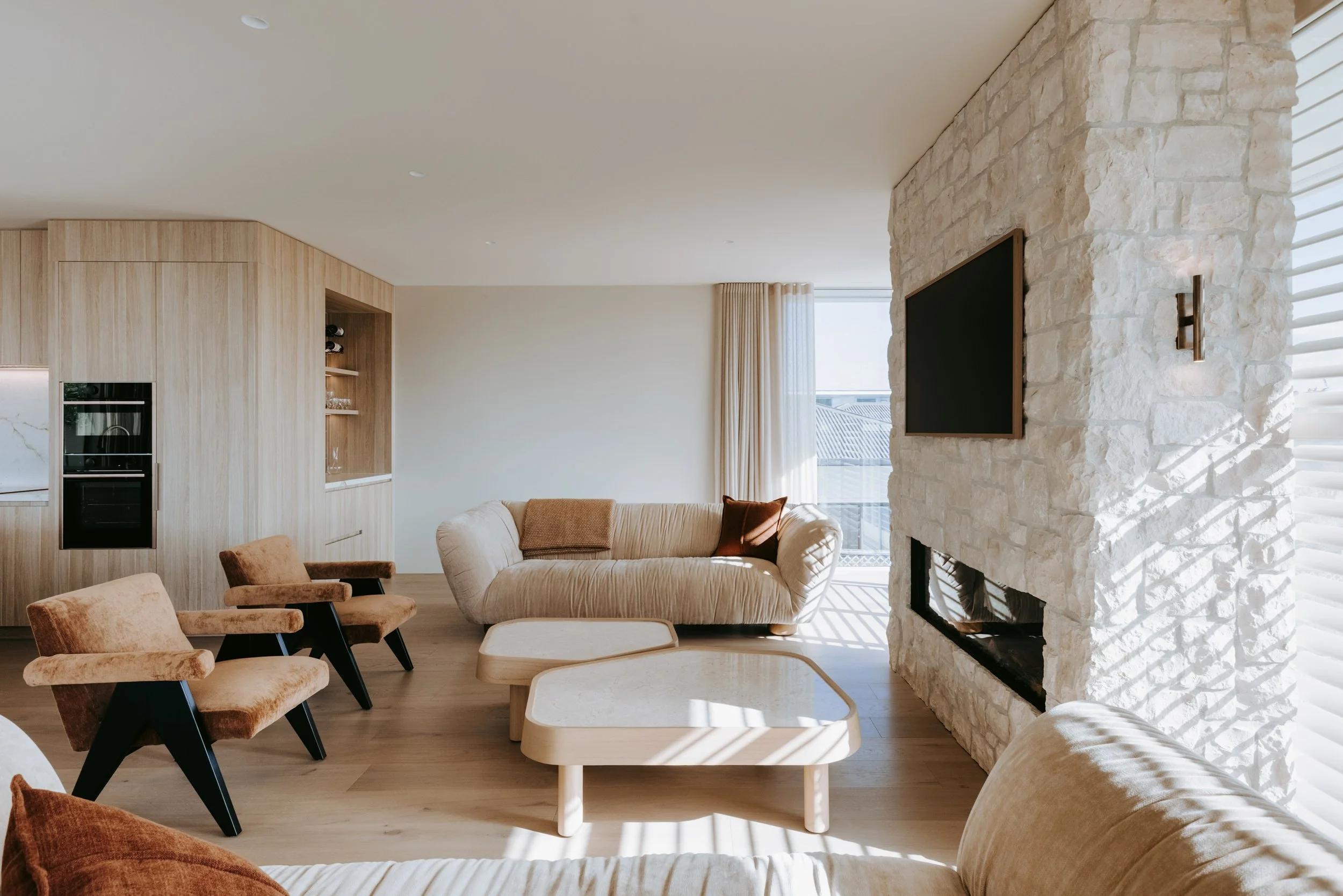 Living room of Palm Springs Mount Maunganui renovation with open-plan layout and natural stonework