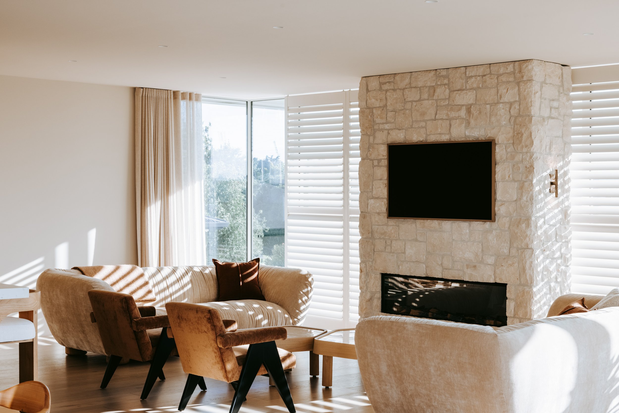 Living room of Palm Springs Mount Maunganui renovation with open-plan layout and natural stonework