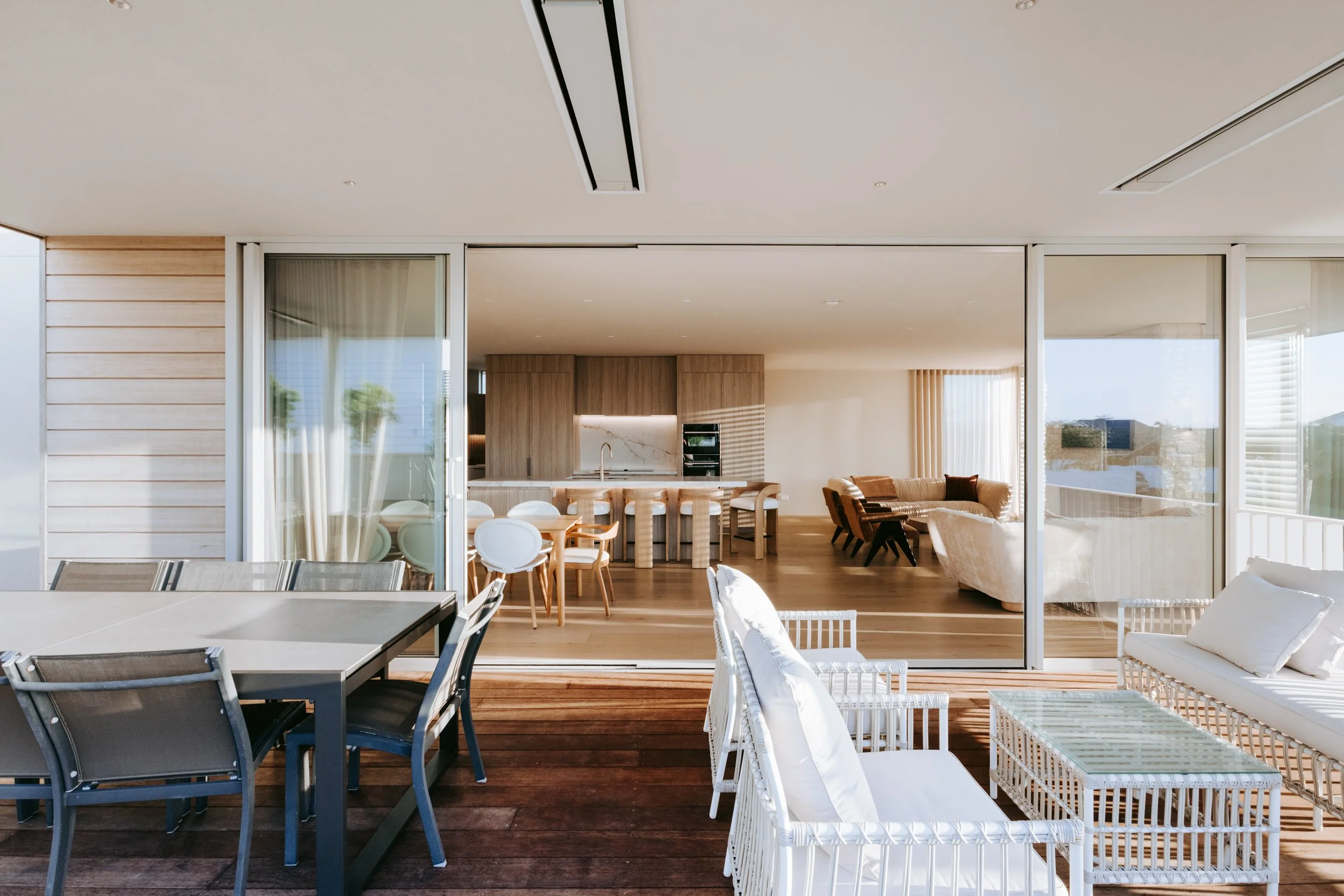 View from outdoor living area into the open-plan kitchen and dining in Palm Springs Mount Maunganui home renovation