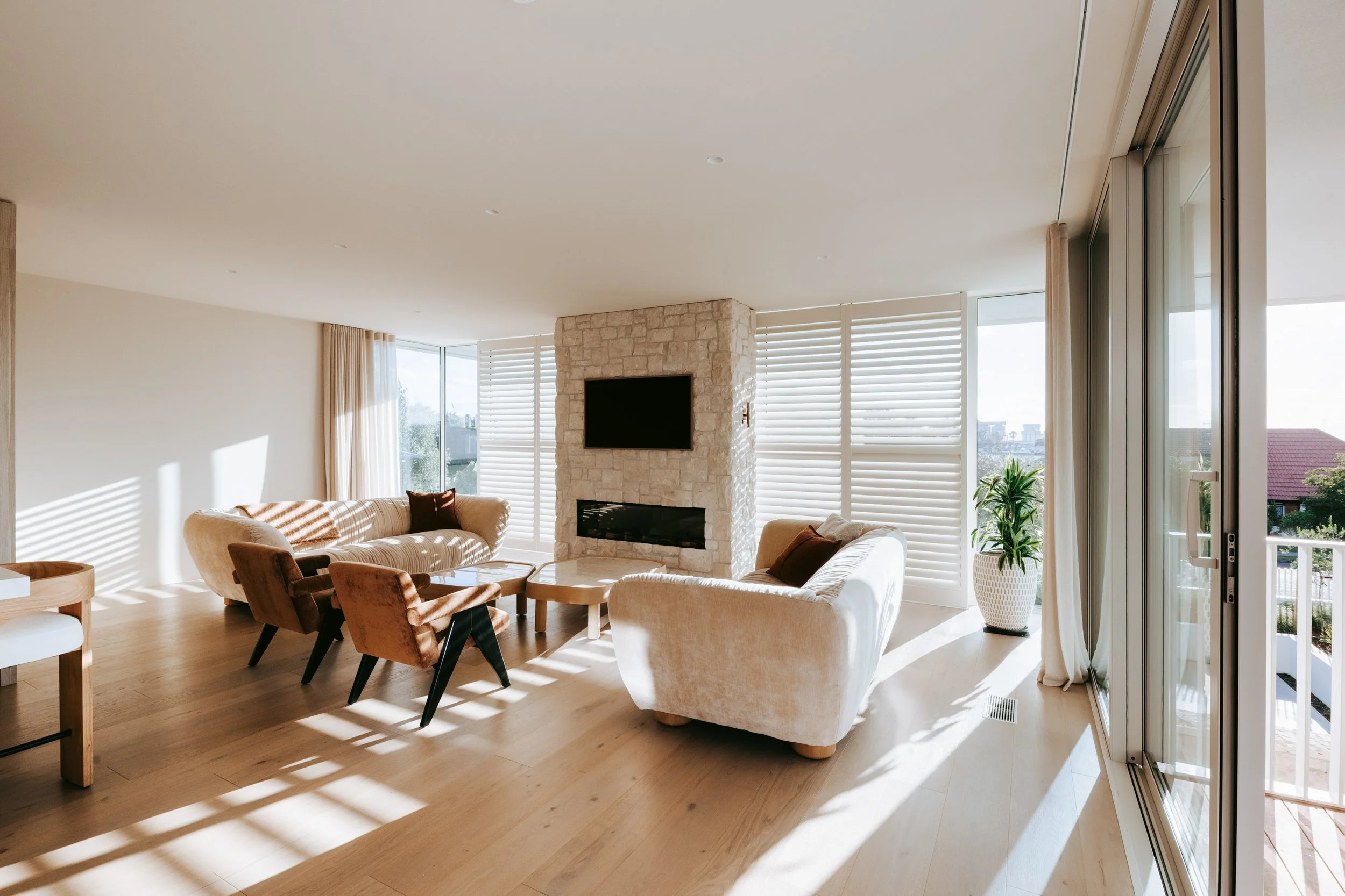 Living room of Palm Springs Mount Maunganui renovation with open-plan layout and natural stonework