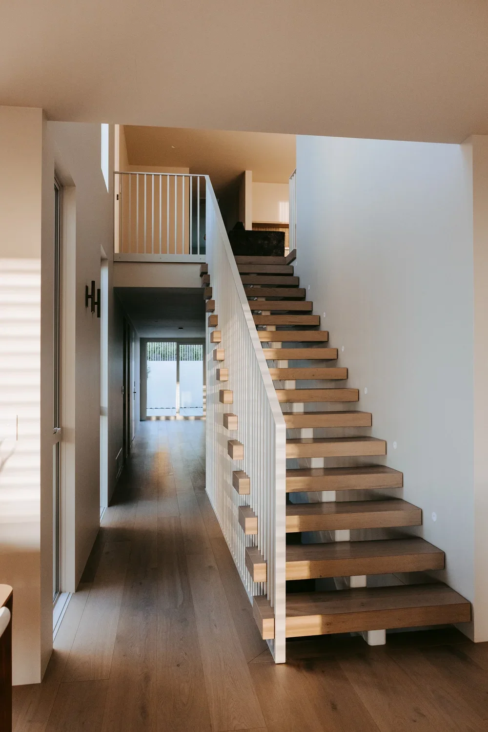 Interior stairs in Palm Springs Mount Maunganui home renovation with timber treads and decorative balustrade