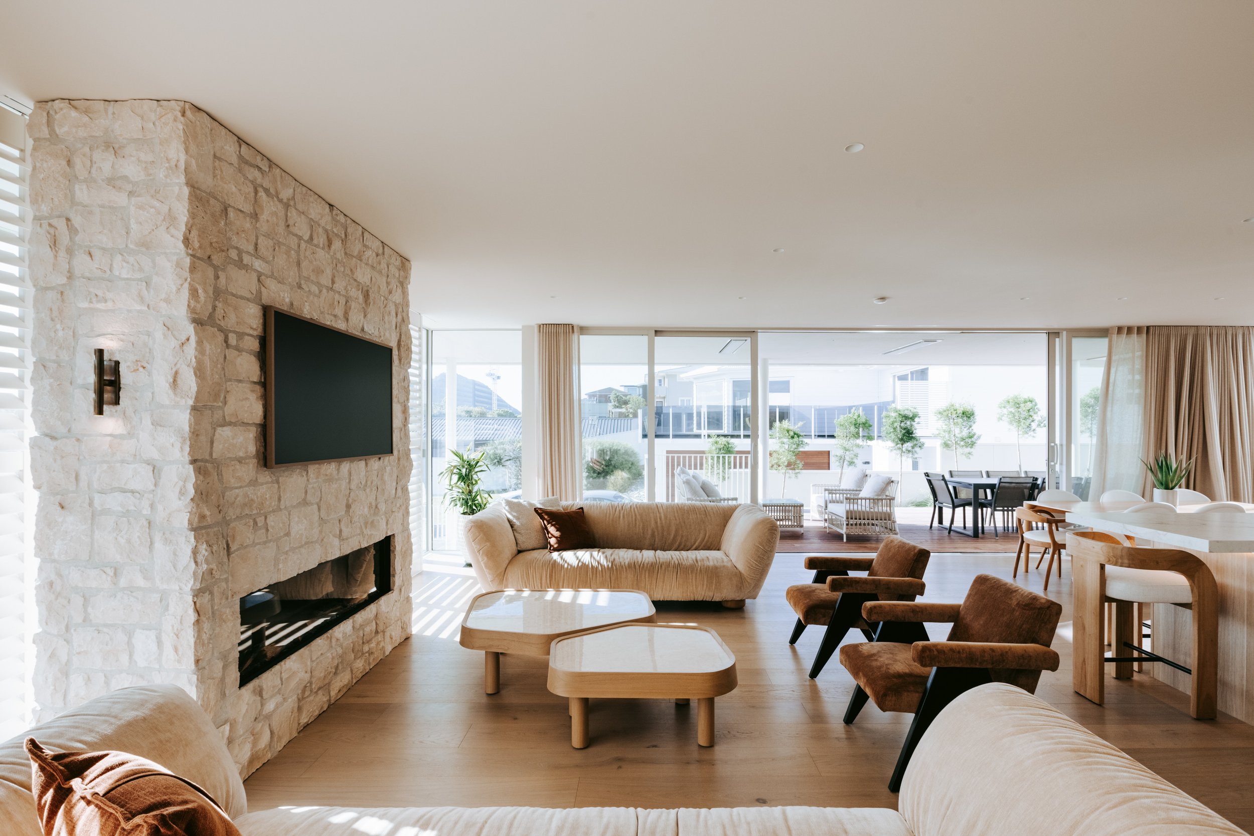 Living room of Palm Springs Mount Maunganui renovation with open-plan layout and natural stonework