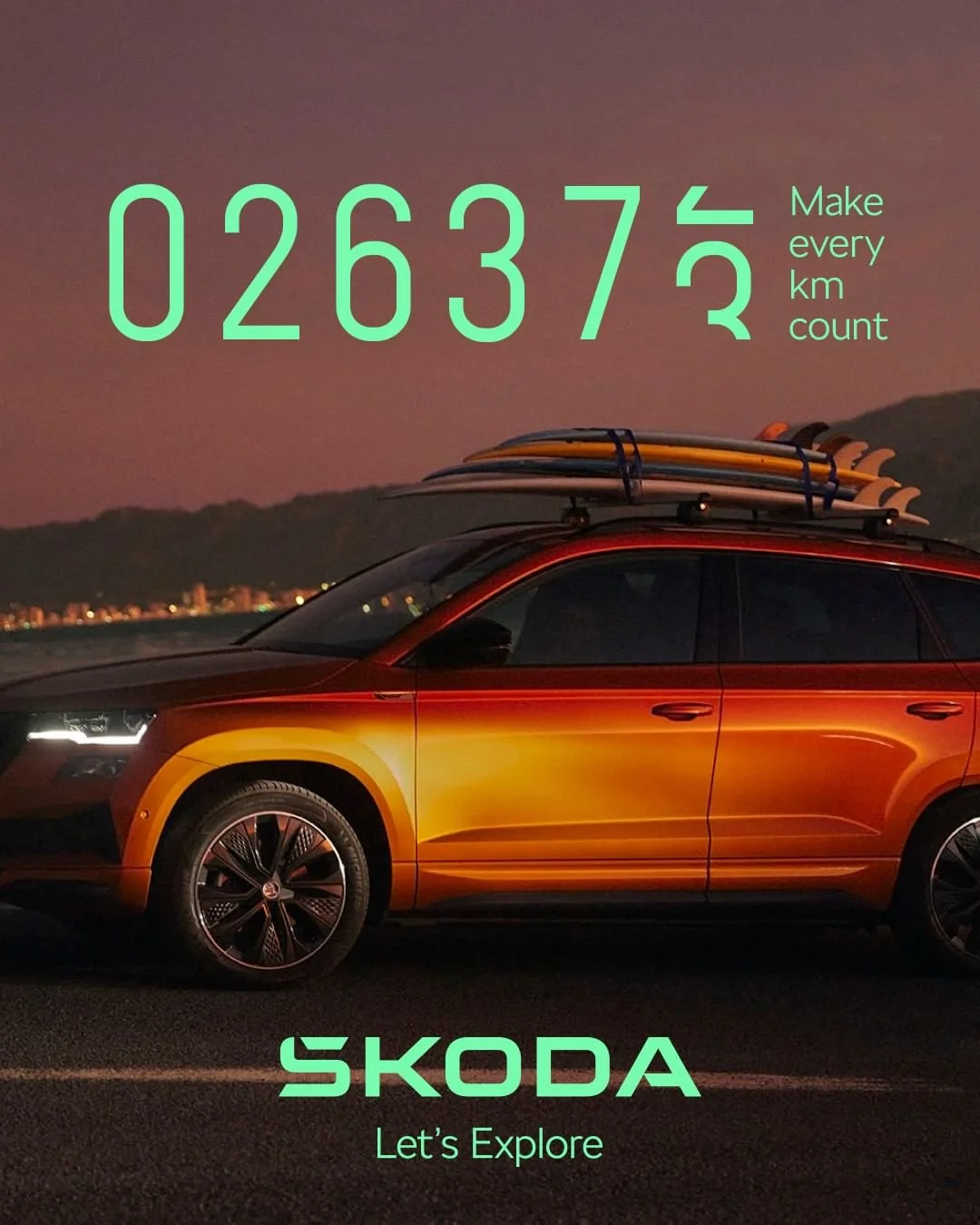 Auto rosso con tavole da surf sul tetto, al tramonto, con testo che invita a esplorare con il marchio Skoda.