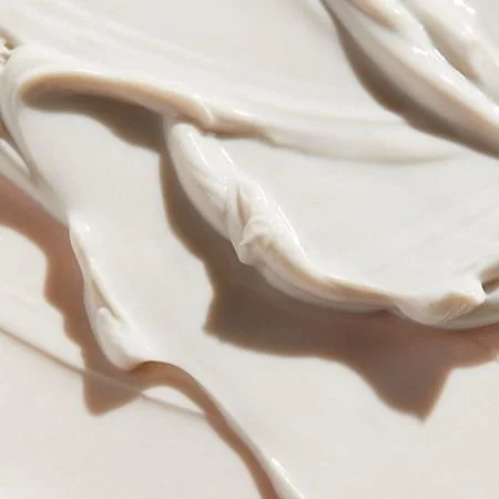 Close-up of white creamy substance, possibly yogurt or sour cream, spread on a surface.