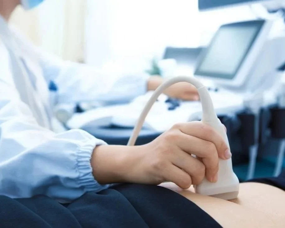 Certified sonographer performing a diagnostic ultrasound scan on a patient in a Saskatoon clinic.