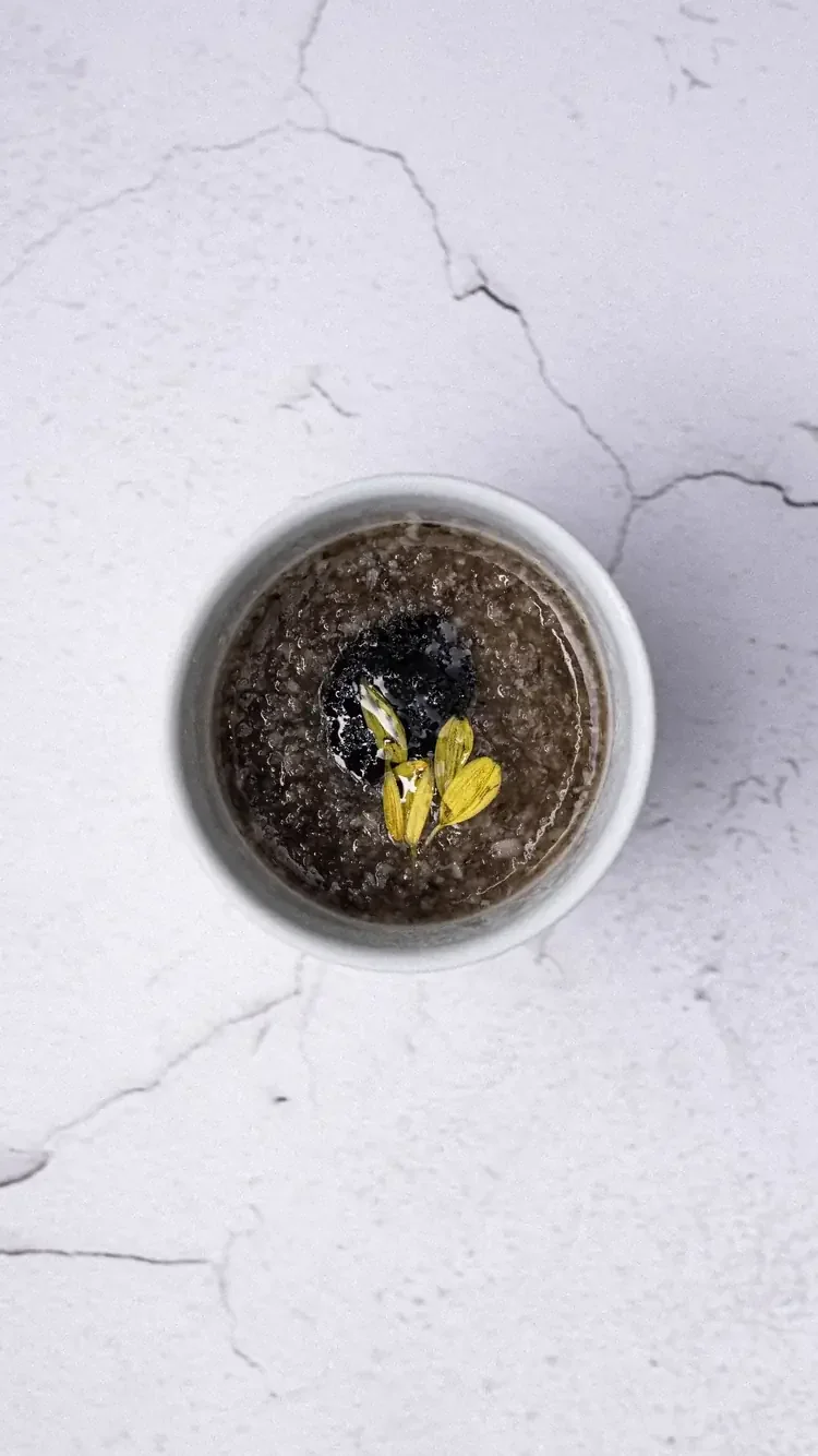 A truffle risotto or mushroom dish in a white ceramic bowl.