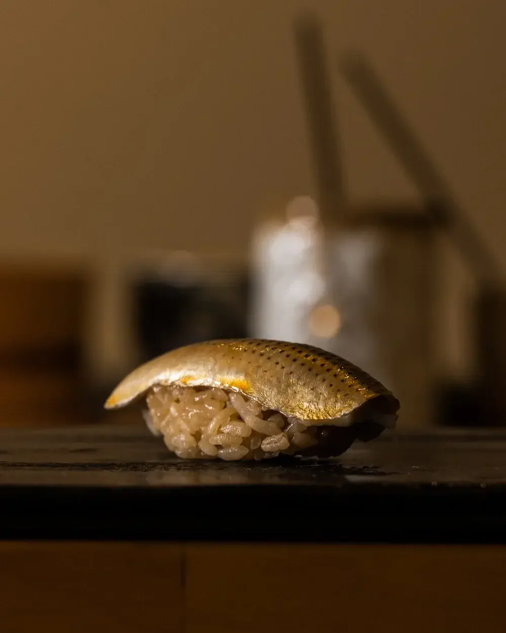 Kohada nigiri sushi with shimmering silver skin on seasoned rice.
