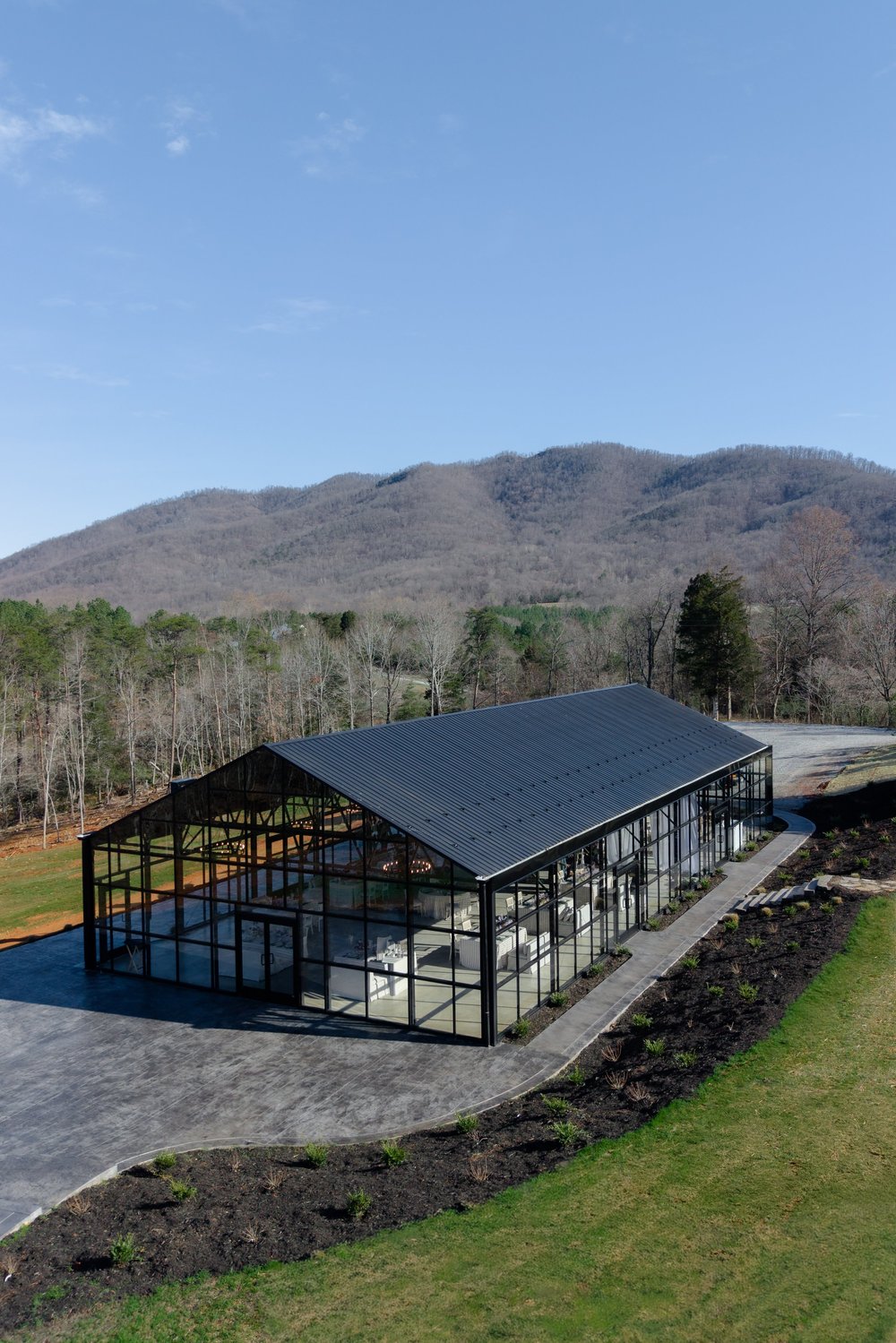 The glass greenhouse at Solara Ridge against the mountains