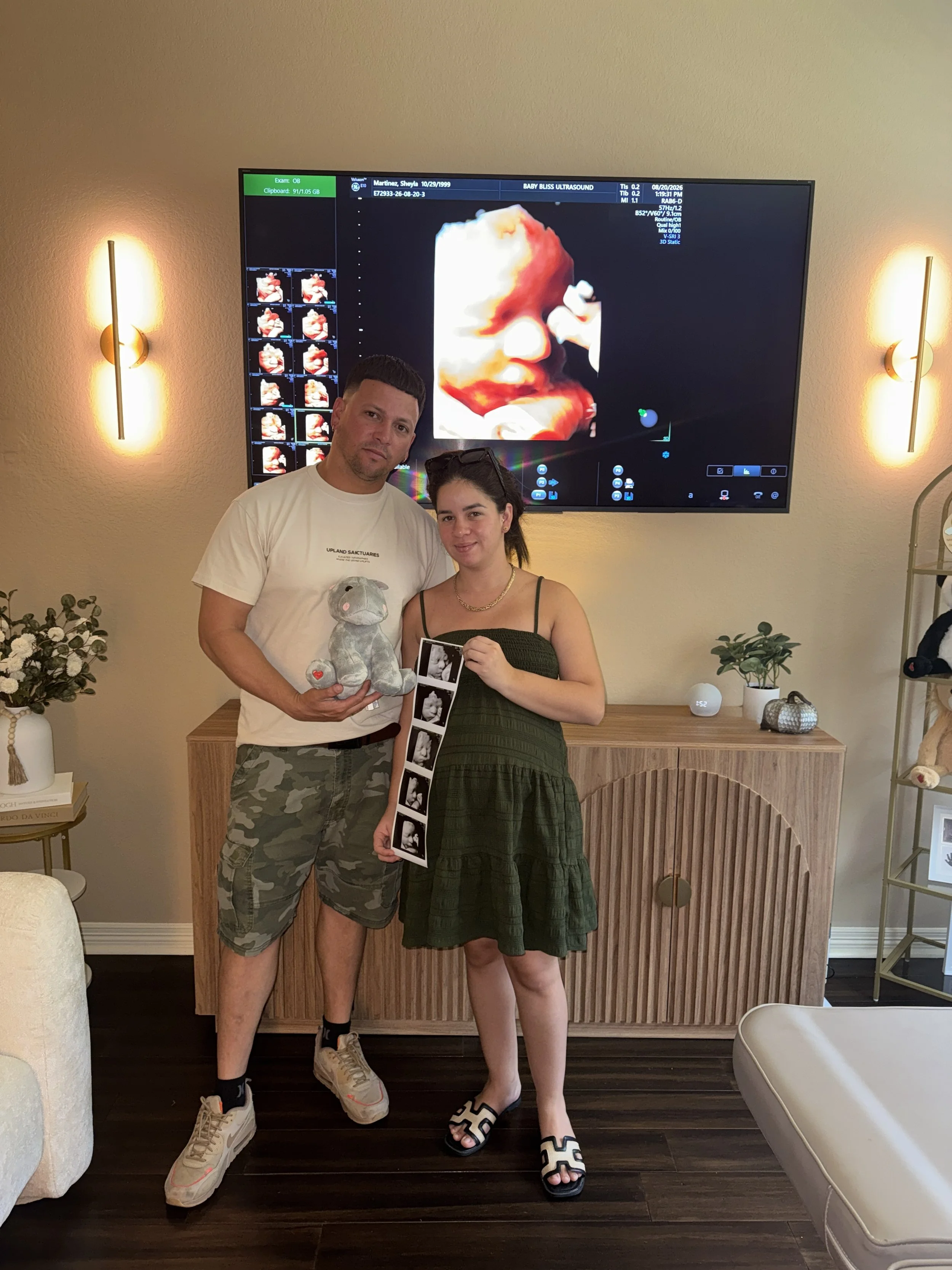 Family holding their 3D/4D ultrasound photo strip after a boutique ultrasound session at Baby Bliss Ultrasound in Houston.