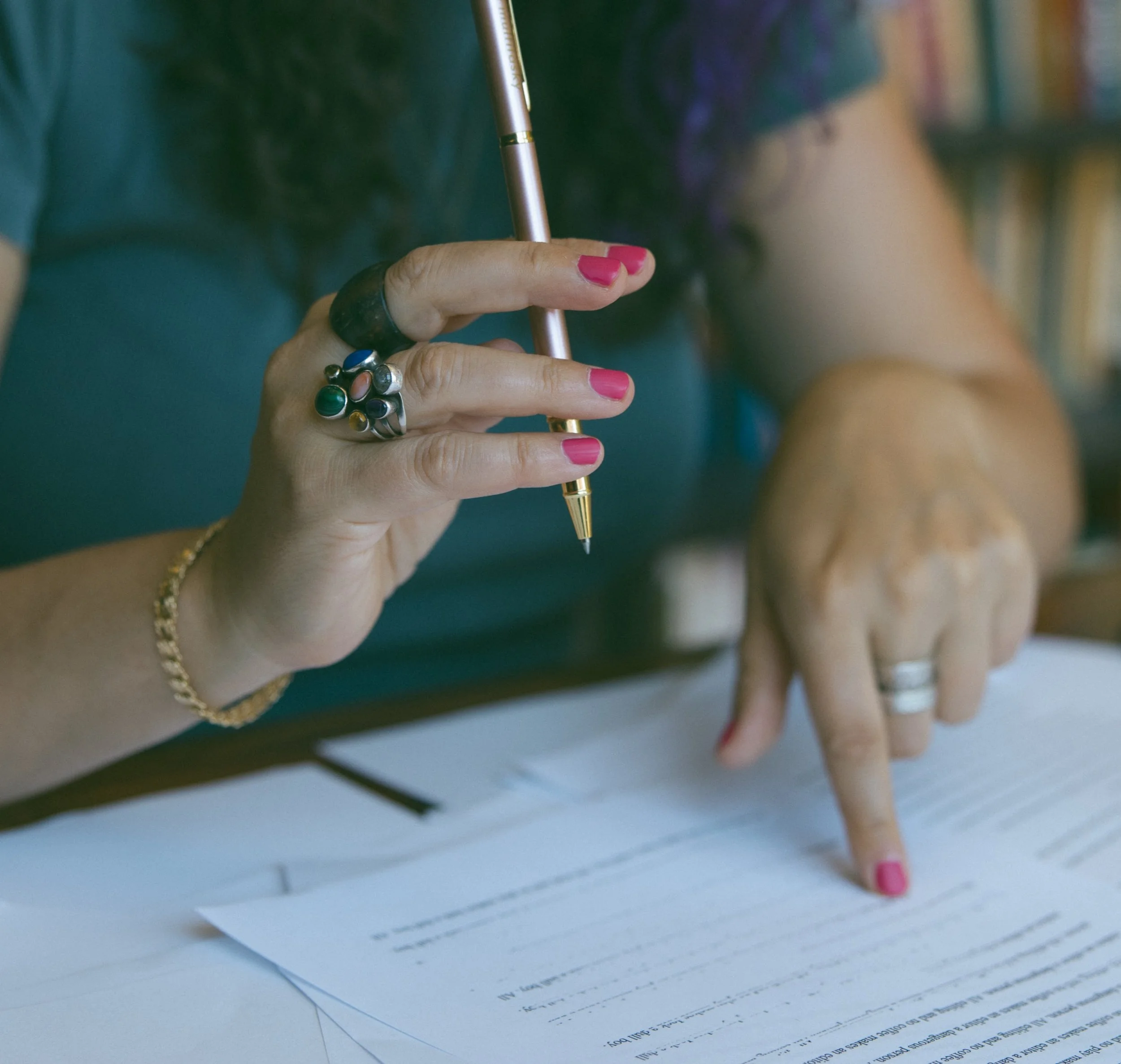 Samantha Pollack, Writing Coach and Editor, reviewing some papers with a pen in hand