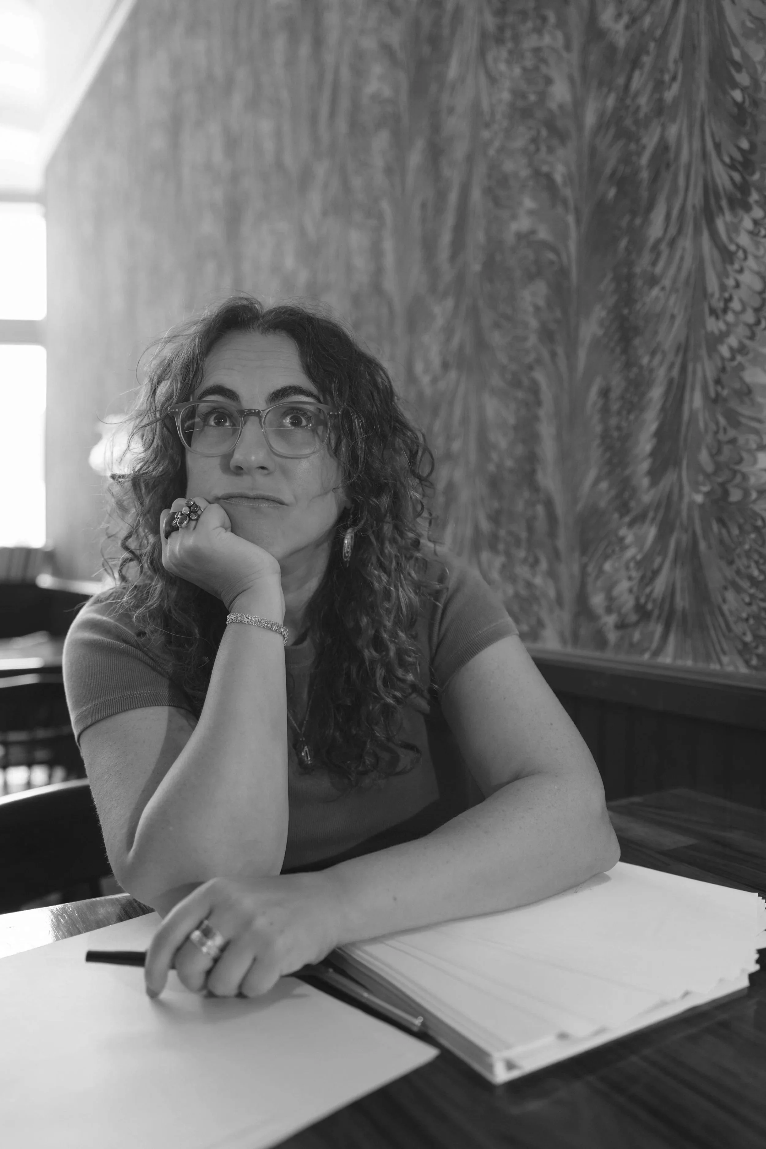 Samantha Pollack, writing coach & editor, with chin in hand working at a desk