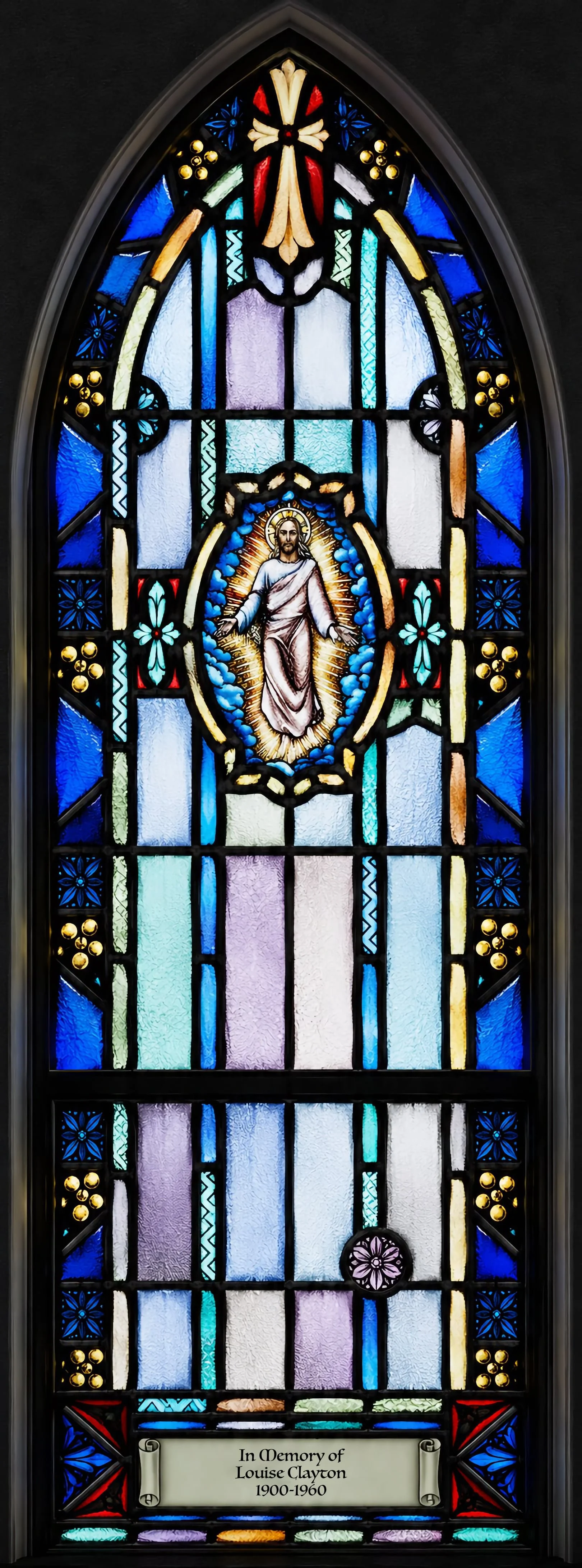 Ascension (Gospel side). Christ rising in glory, his body encircled by an aureole, the edge of the earth visible beneath his feet (Acts 1:9). Given "In Memory of Louise Clayton, 1900–1960."