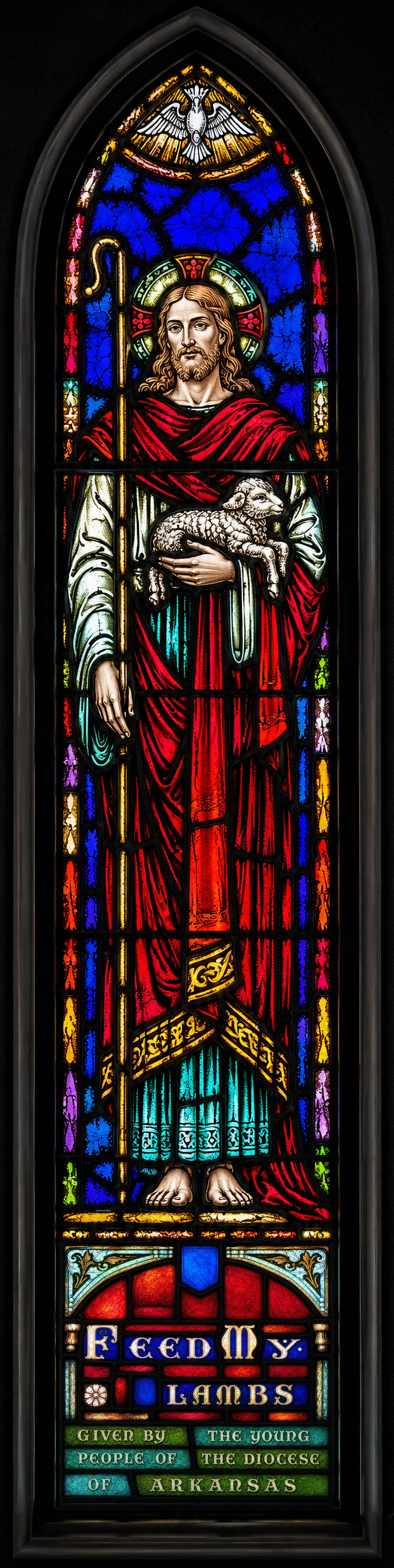 The Good Shepherd. Above the altar, Jesus holds a lamb and a shepherd's crook beneath a descending dove. The artist depicts Christ as he appeared to the disciples after the Resurrection, when he said, "Feed my lambs" (John 21:17).