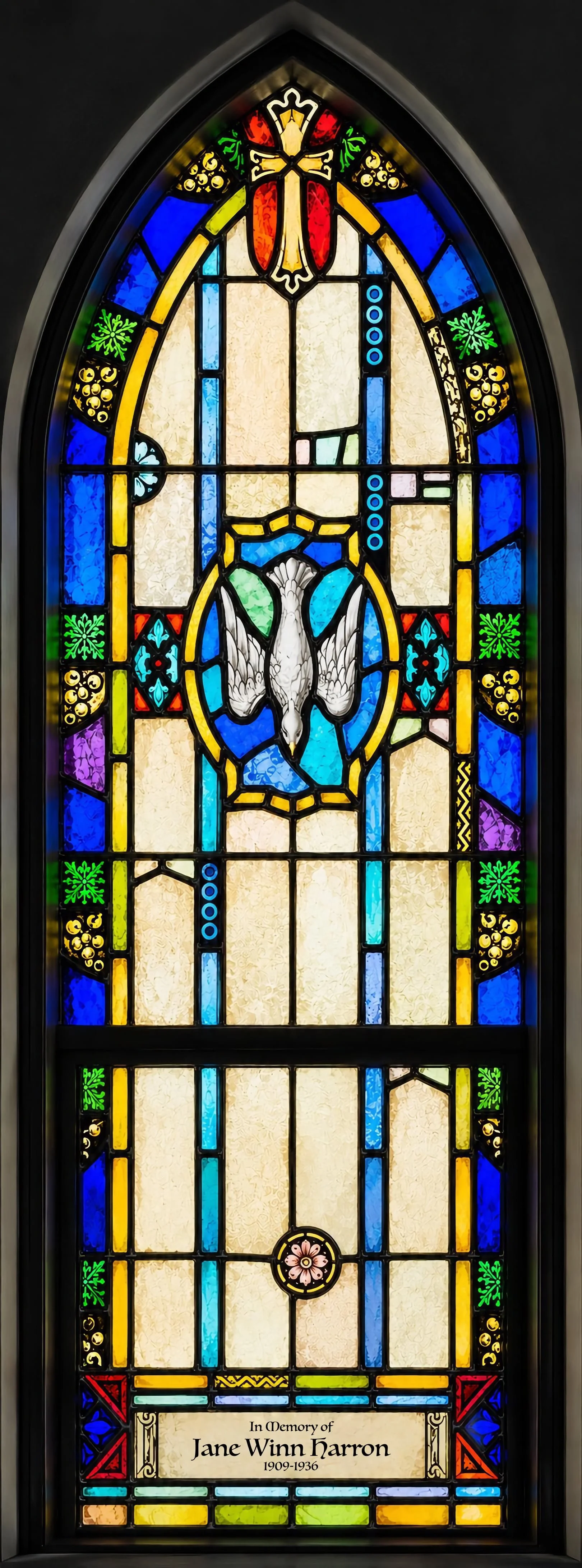 The Descending Dove. The same Holy Spirit who hovered above Christ in the Chapel window, here descending to bless the waters of Baptism.