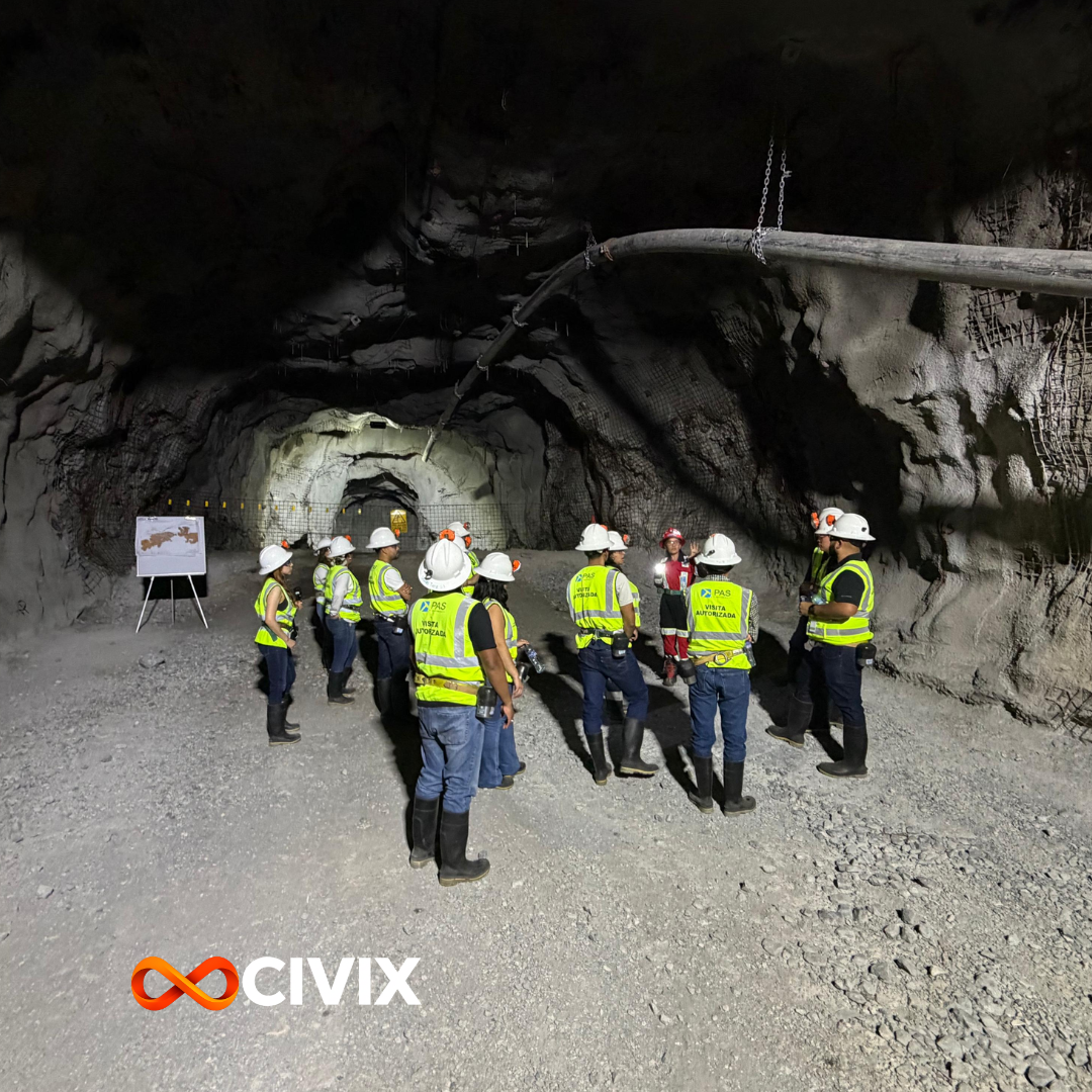 Grupo de personas con cascos y chalecos de seguridad en una mina subterránea, realizando una visita guiada.