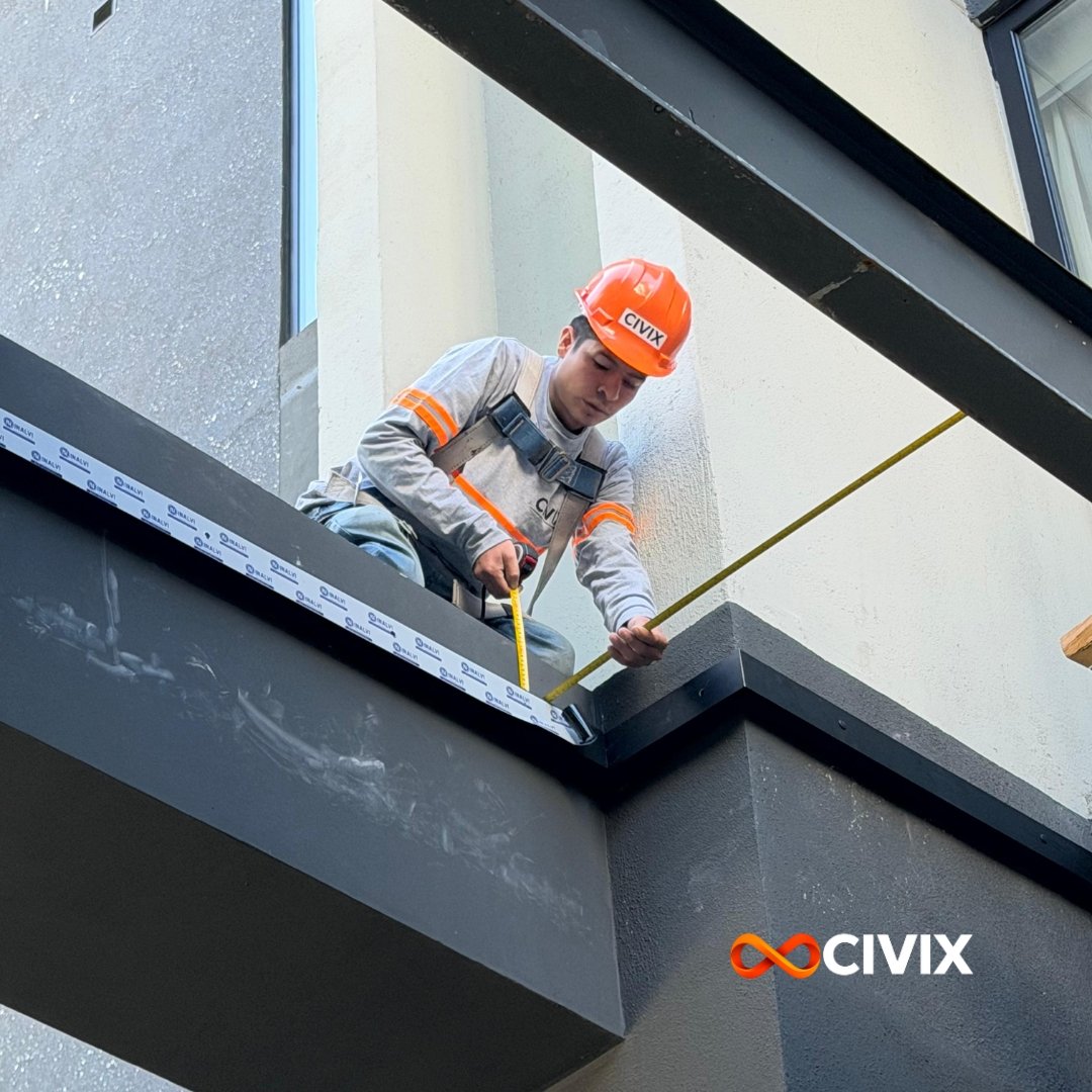 Estructura metálica de una construcción en proceso, con vigas de acero y soportes, bajo cielo nublado.