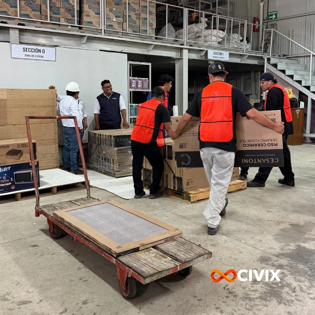 Equipo de CIVIX con chalecos reflectantes junto a un camión abierto con materiales embalados para su movilización y descarga.