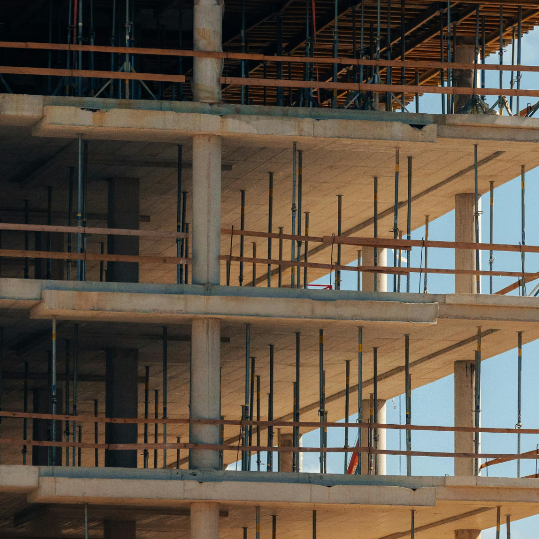  Estructura de edificio en construcción con pisos de concreto y andamios de madera y metal.