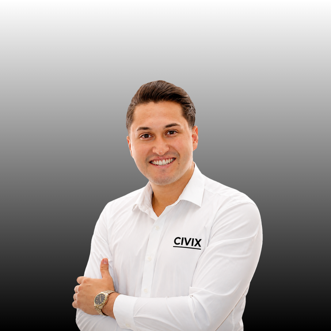 Hombre sonriente con camisa blanca y reloj, fondo de degradado gris oscuro a claro.