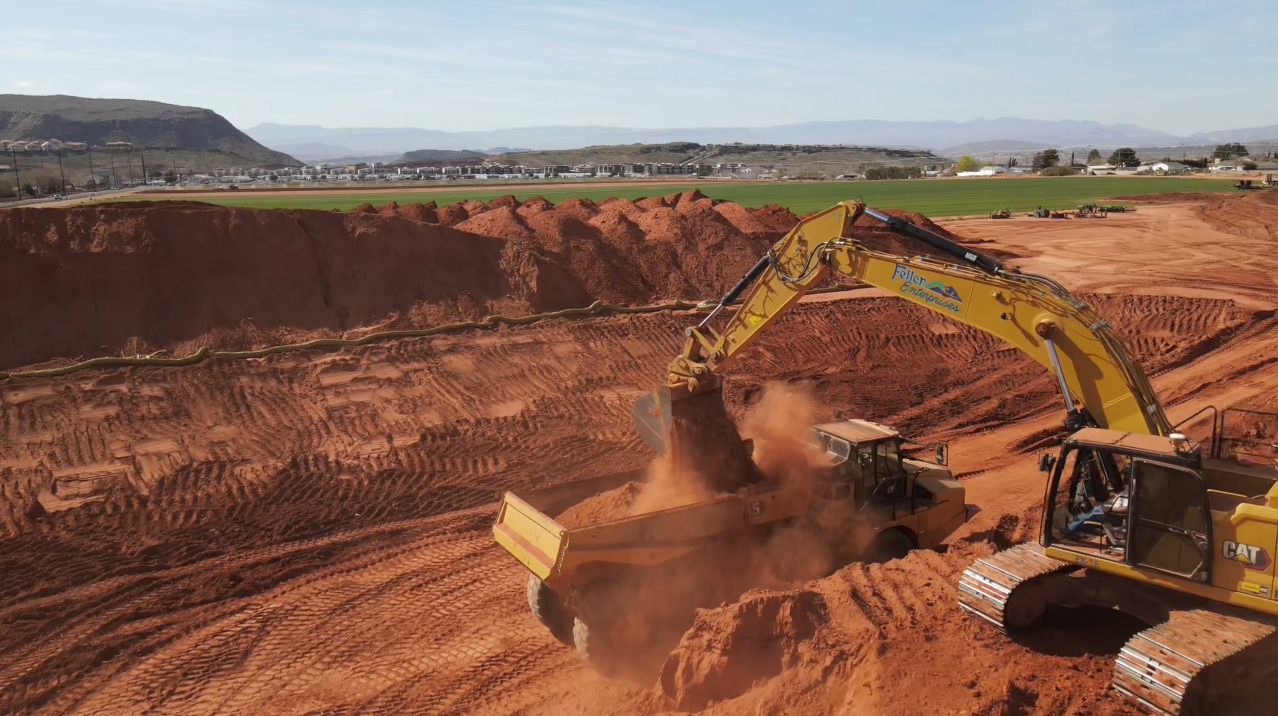 Excavator grading earth at an active real estate development construction site