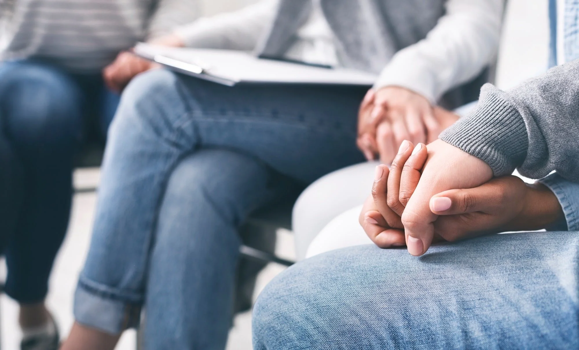 Two people sitting together in conversation, representing community collaboration for teen mental health