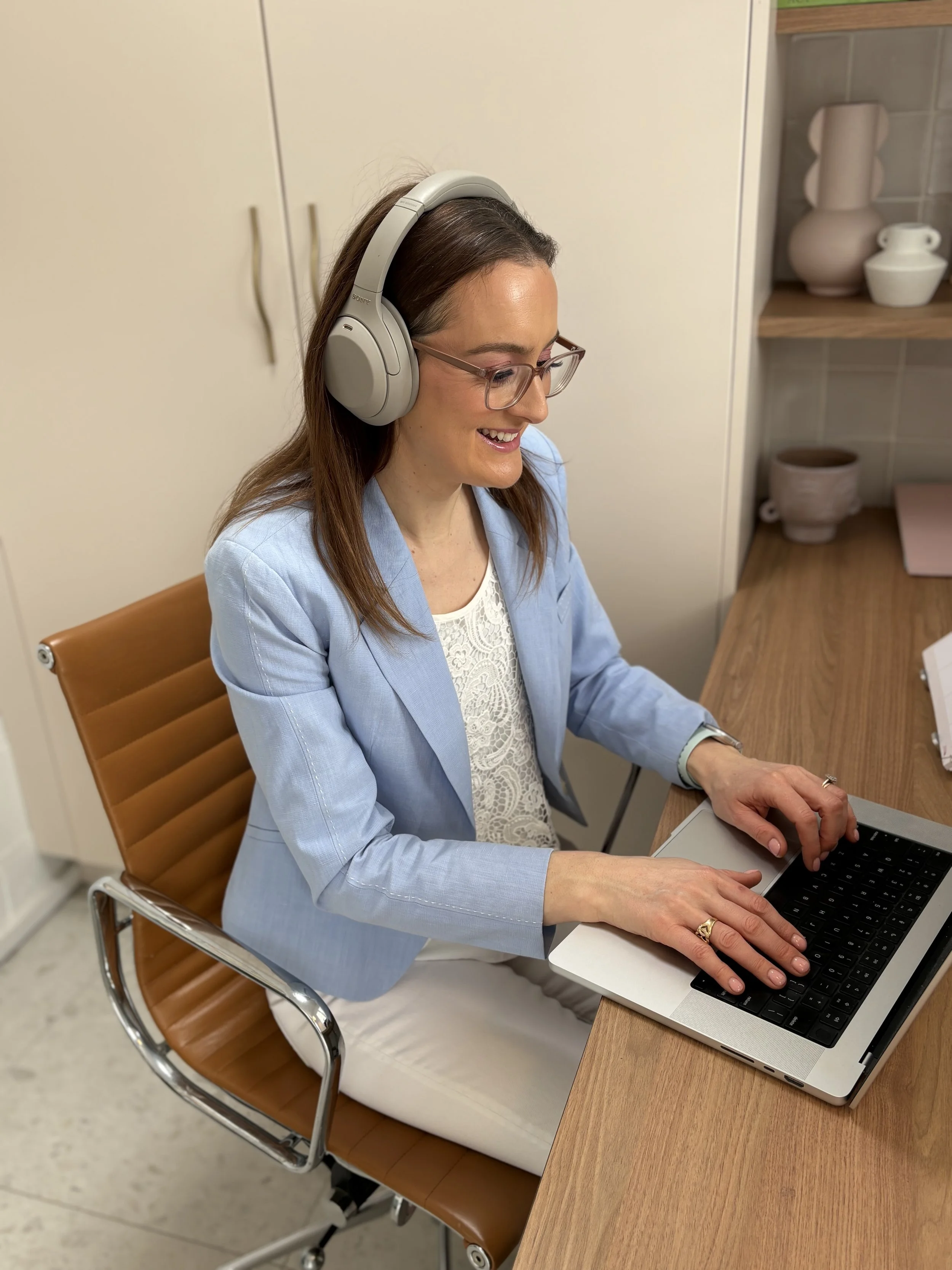 Jazmin Pursell smiling at desk, delivering online training to helping professionals