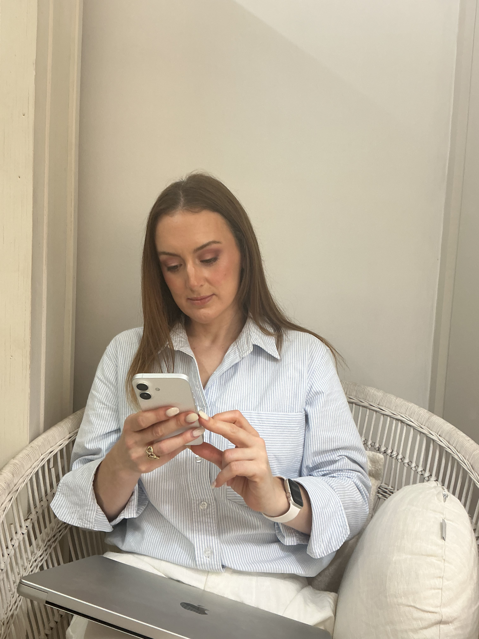 Jazmin Pursell sitting, reading text messages on iphone