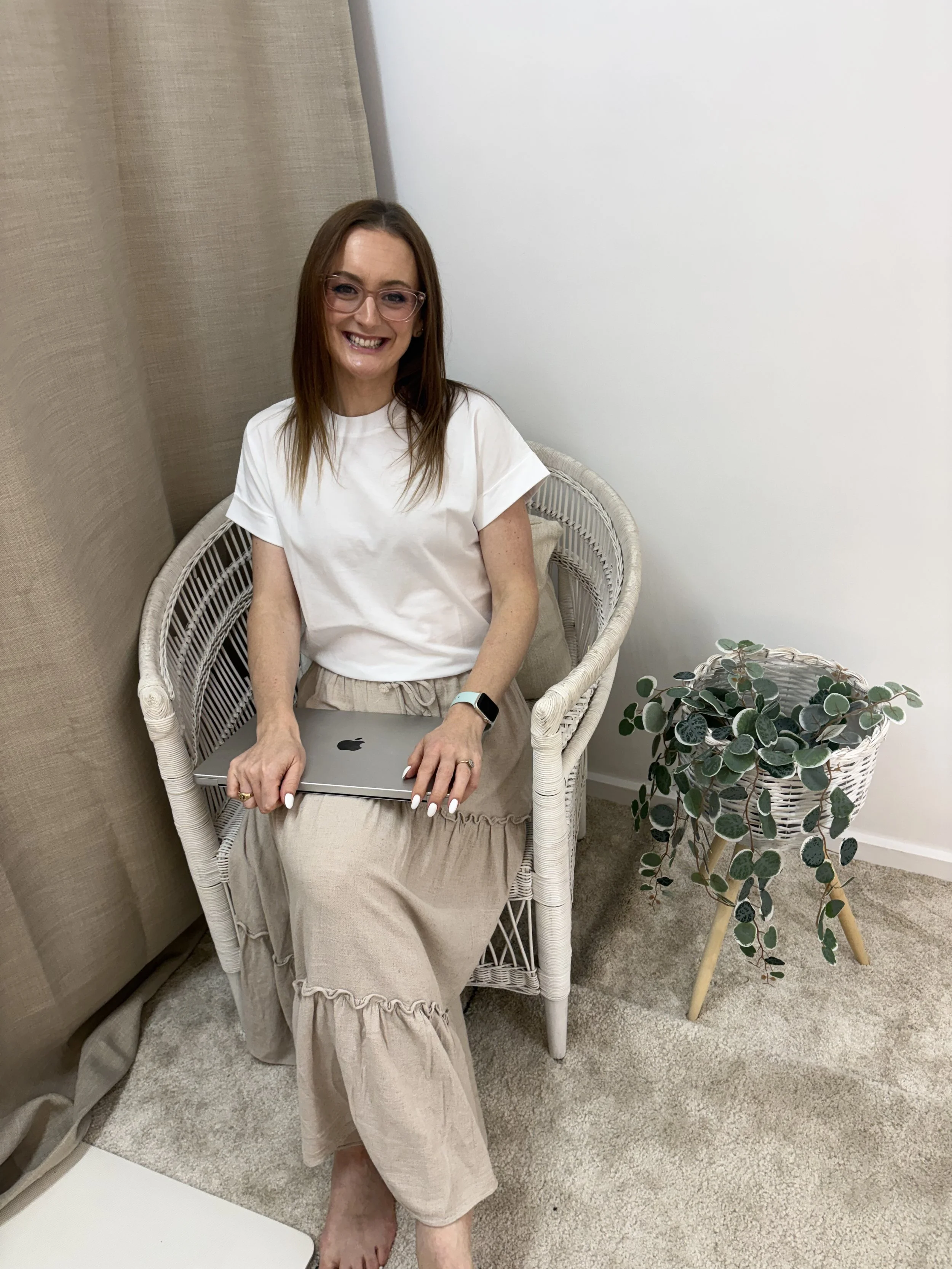 Jazmin Pursell, sitting on chair with MacBook on lap