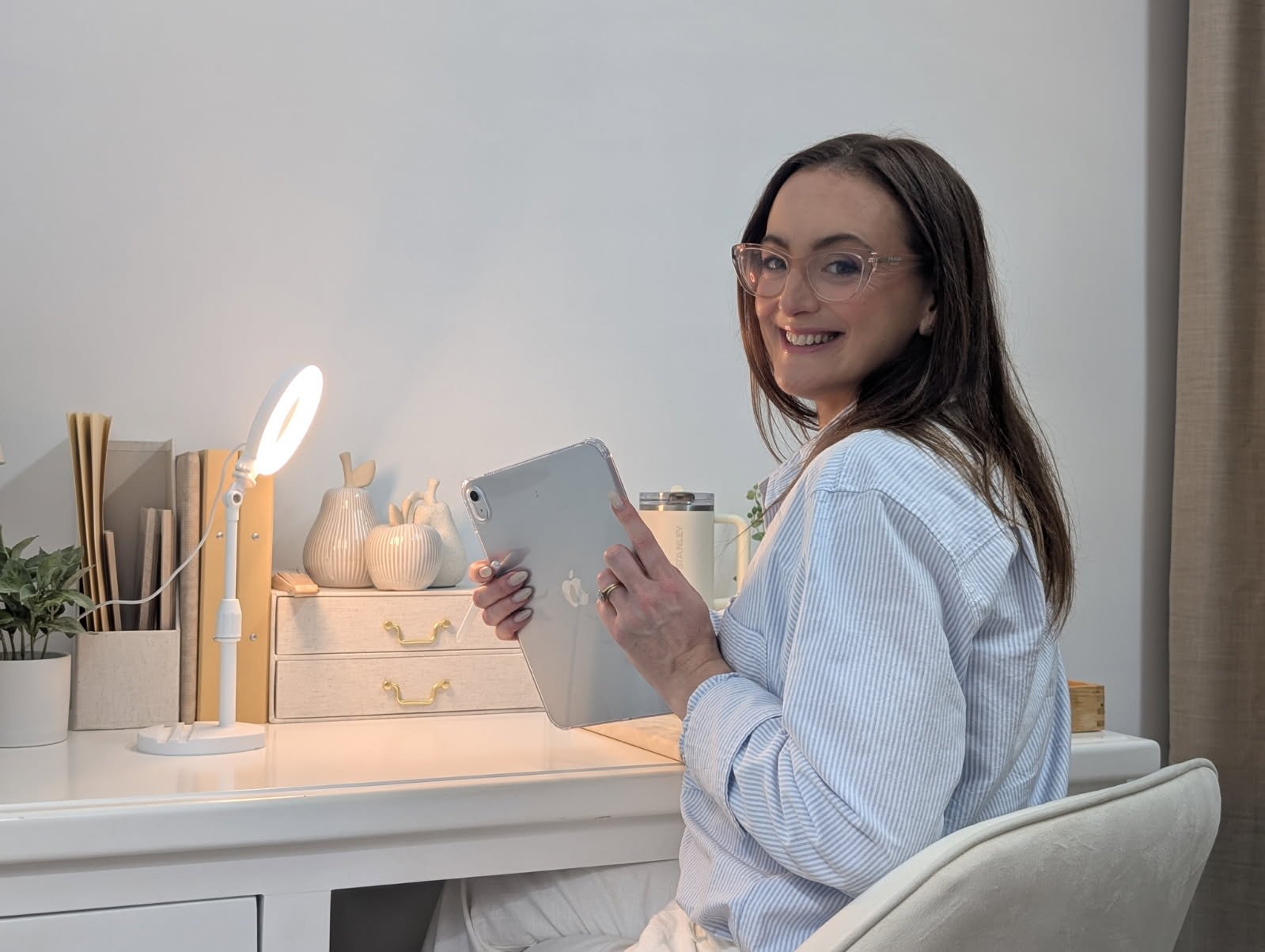 Jazmin Pursell in office at desk, turning around, smiling