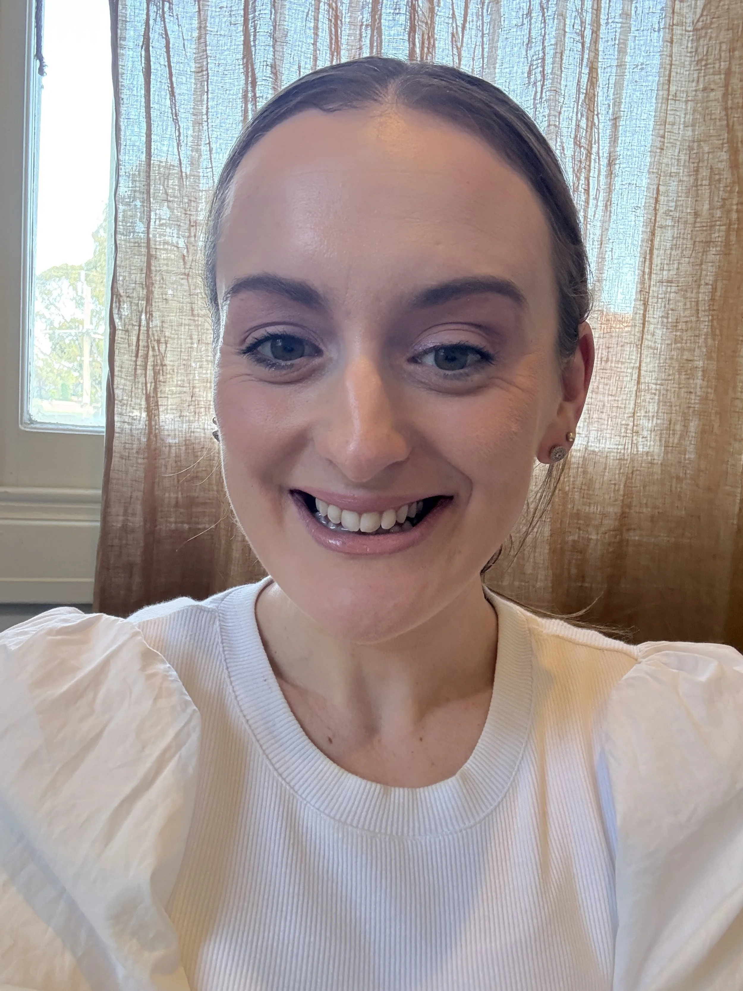 Jazmin Pursell sitting, smiling, in front of window