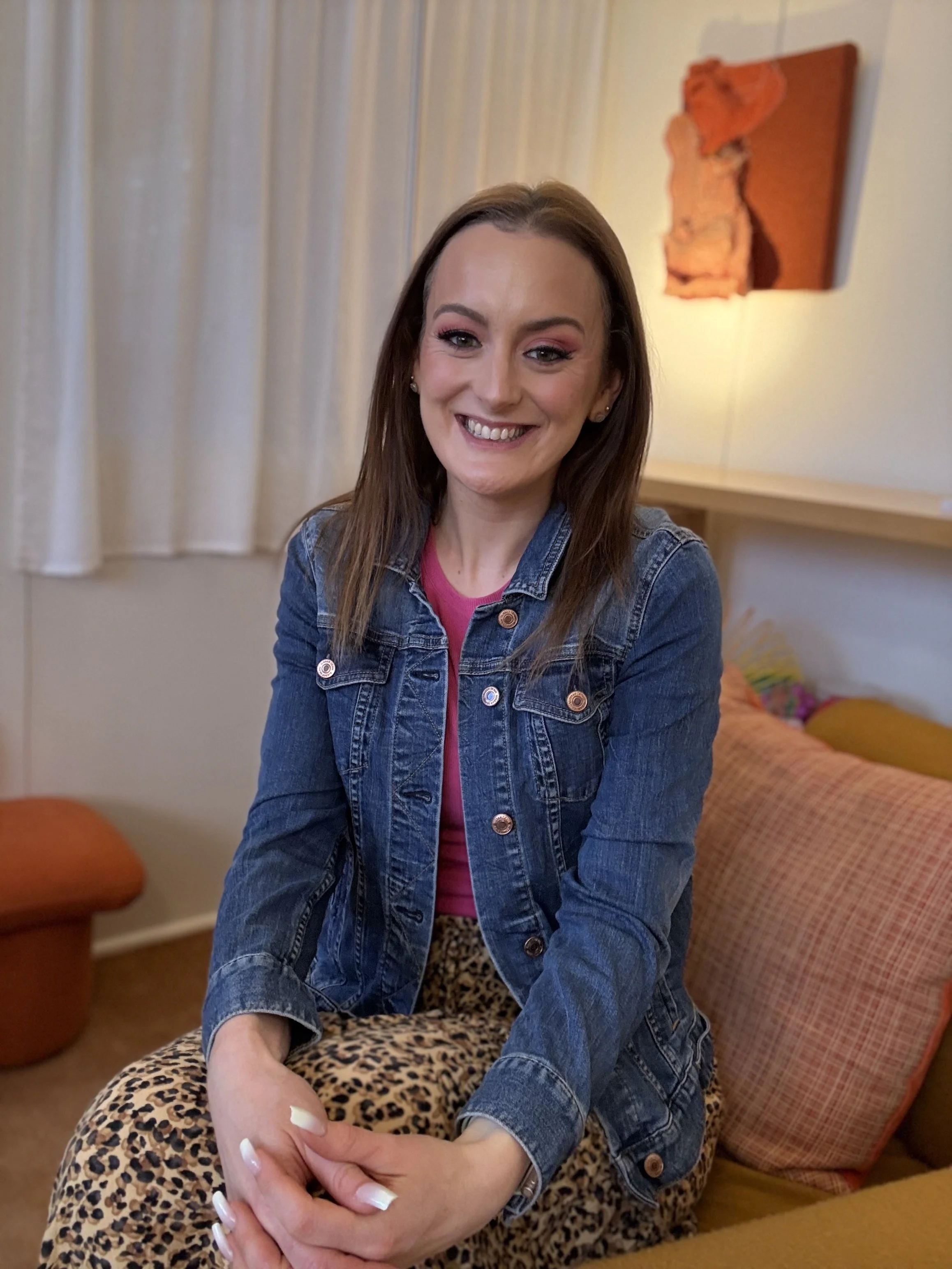 Jazmin Pursell, sitting on couch and smiling