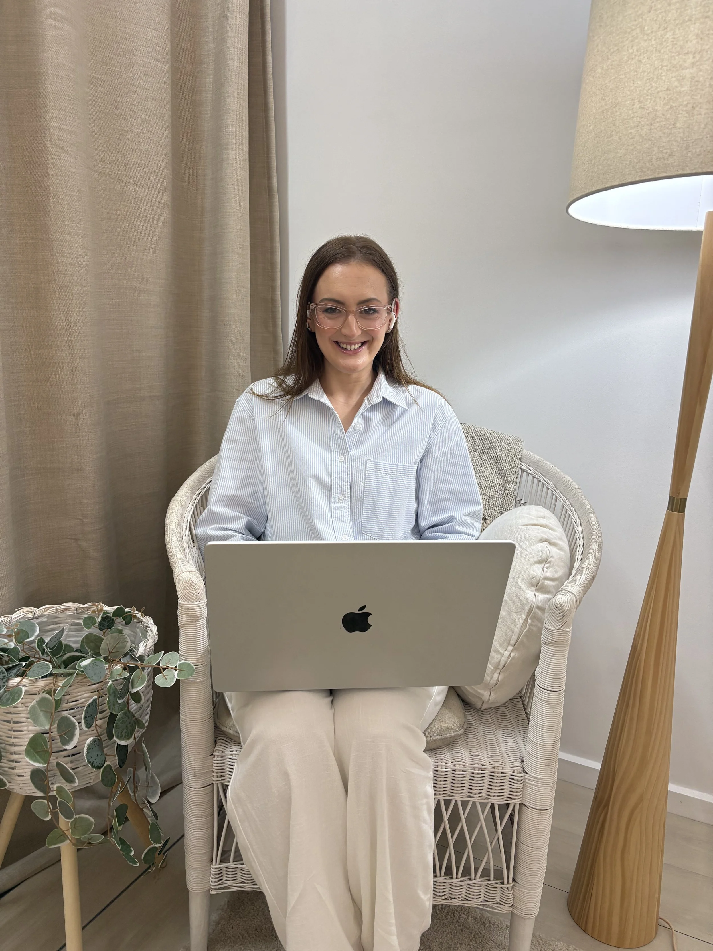 Jazmin Pursell sitting on chair with open MacBook, smiling